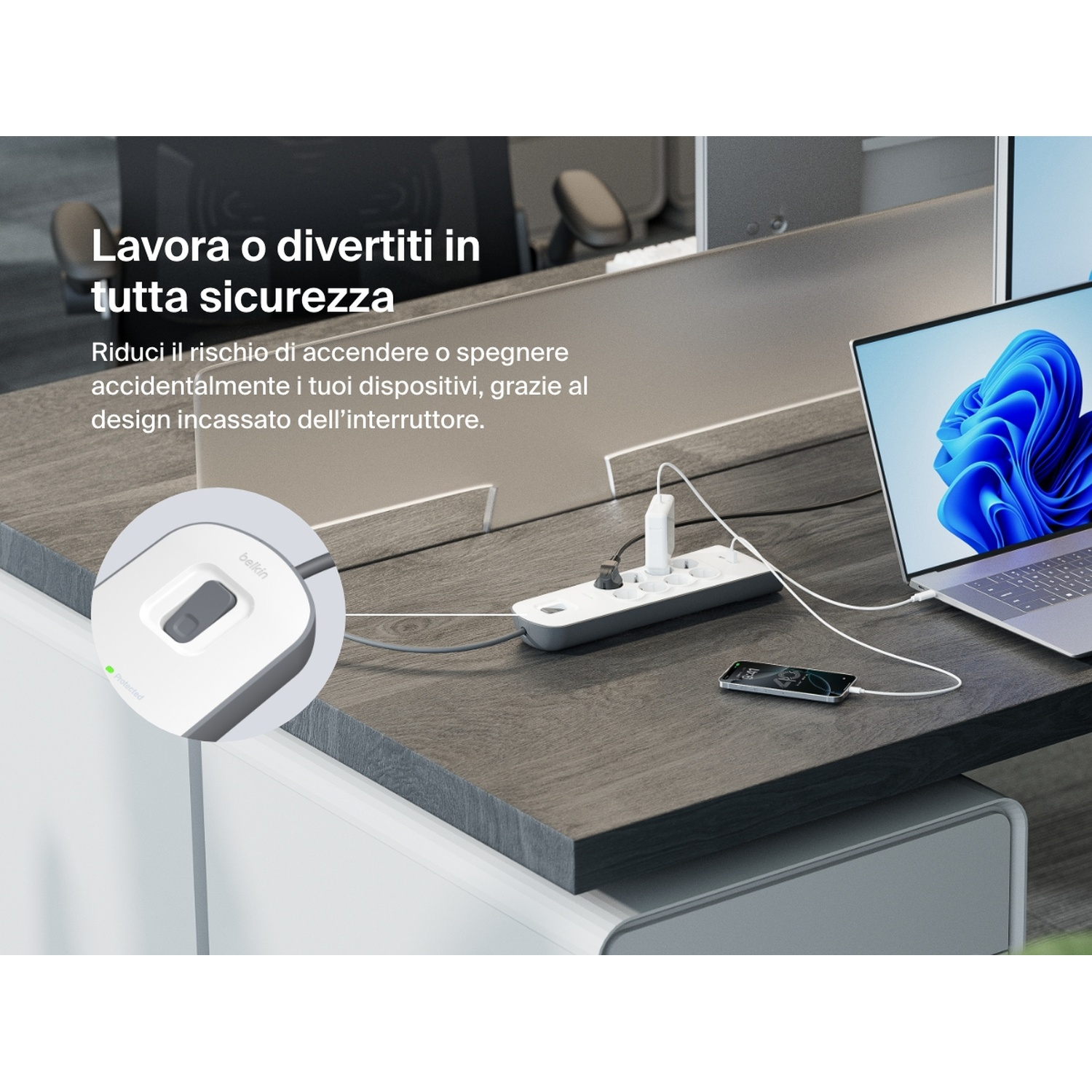Una scrivania con laptop, ciabatta e telefono in carica. Il testo italiano evidenzia la sicurezza e la prevenzione dello spegnimento accidentale.