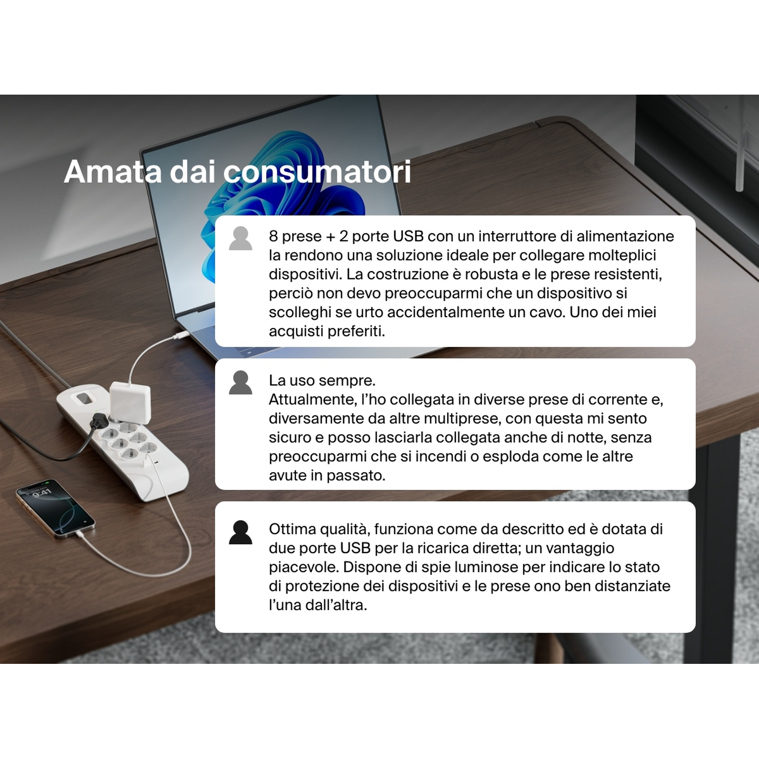 Una ciabatta con laptop e telefono in carica. La ciabatta ha prese e porte USB su un tavolo di legno.