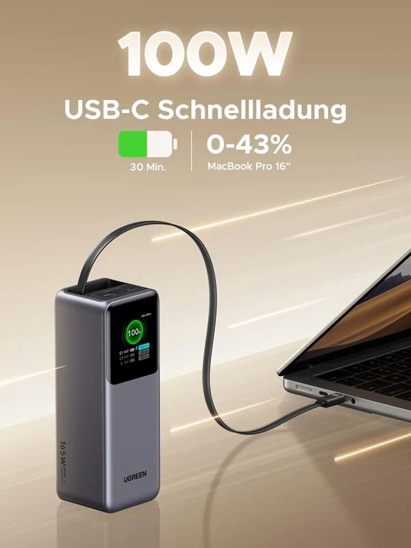 Eine Powerbank lädt ein MacBook Pro. Die Powerbank ist grau mit einem Bildschirm und zeigt 100%. Das Kabel ist verbunden.