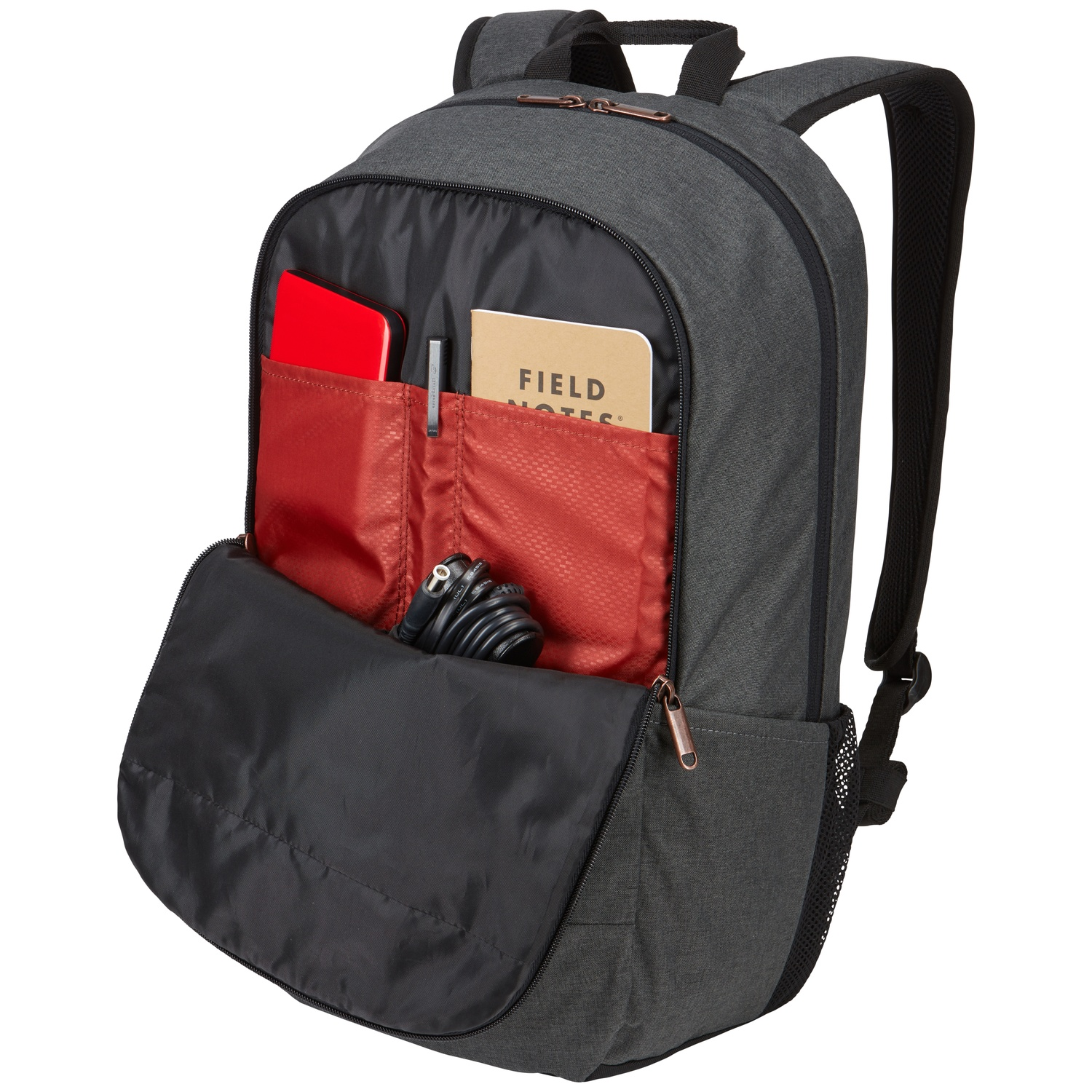 Sac à dos gris avec poches ouvertes révélant un cahier rouge, un stylo, un bloc-notes beige et un câble noir. Poche noire ouverte.