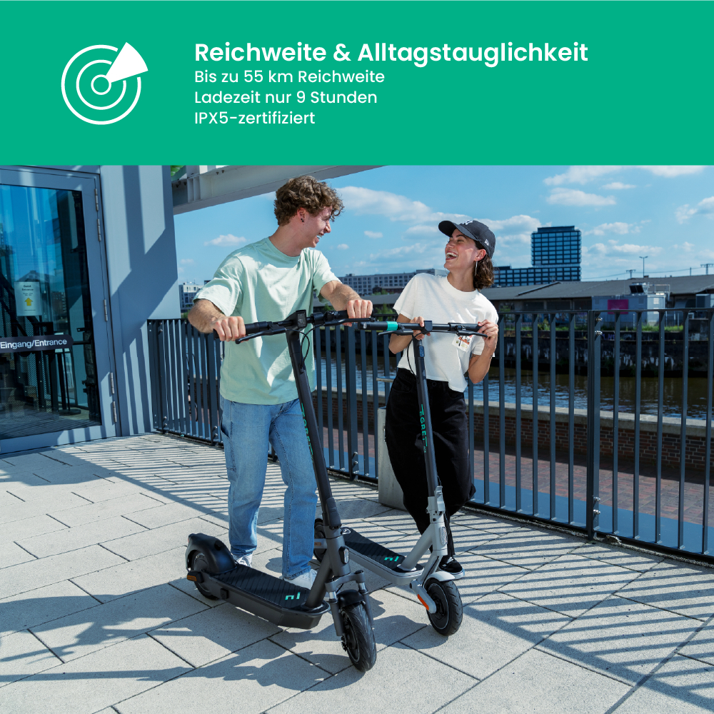 Zwei Personen mit Rollern lächeln im Freien. Der Text oben lautet Reichweite & Alltagstauglichkeit.