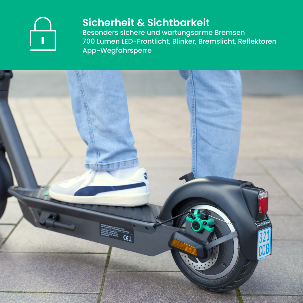 Eine Person auf einem schwarzen Elektroroller. Die Person trägt blaue Jeans und weiße Schuhe. Der Roller hat ein Nummernschild.