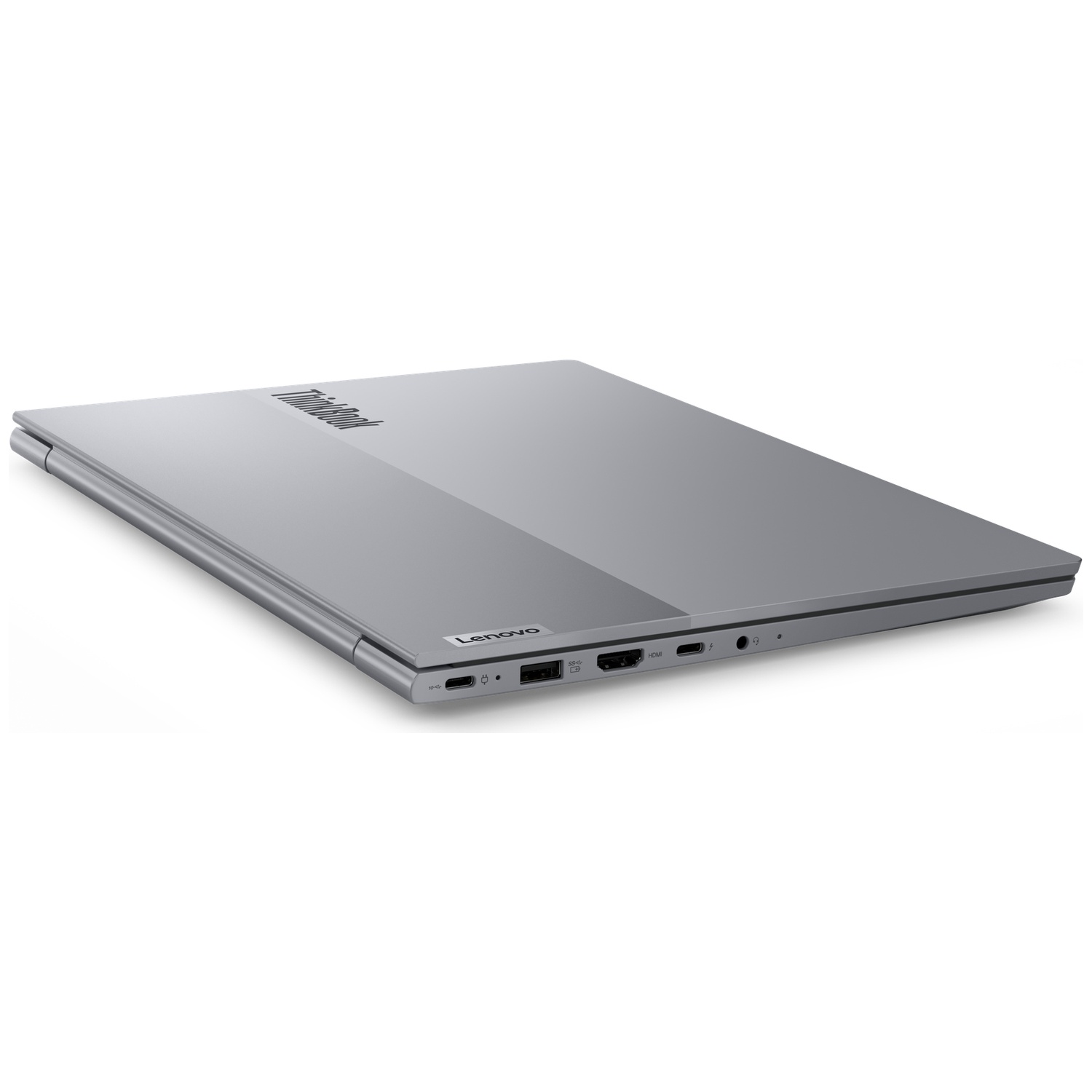 A closed silver Lenovo ThinkBook laptop on a white surface. The laptop is angled, showing the top and side with ports.