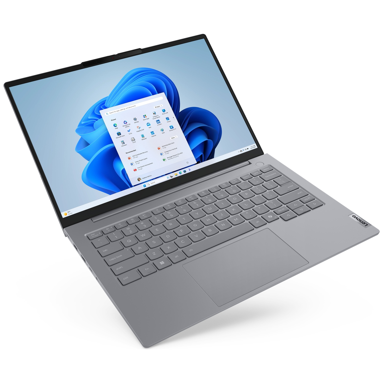 A gray Lenovo laptop is open, displaying a blue Windows 11 desktop. The keyboard is visible, and the screen shows app icons.