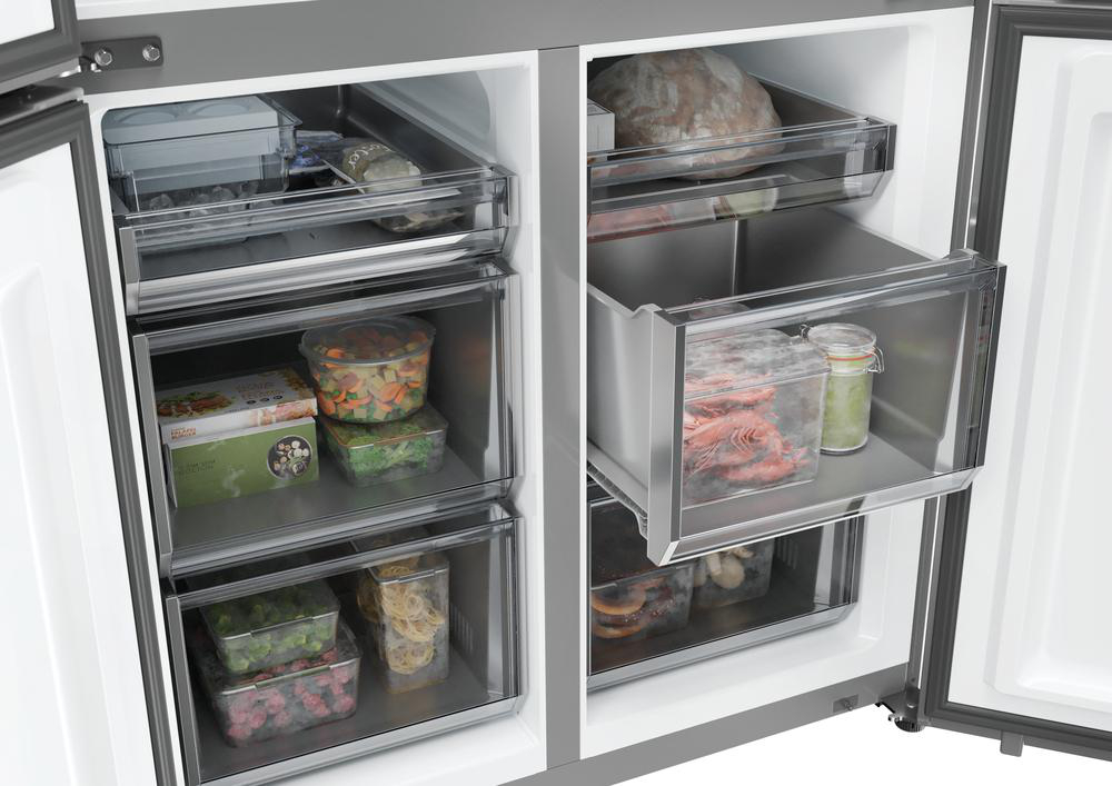 Offener Kühlschrank mit Inhalt: Gemüse, Garnelen, Brot und andere Lebensmittel in transparenten Behältern und Schubladen.