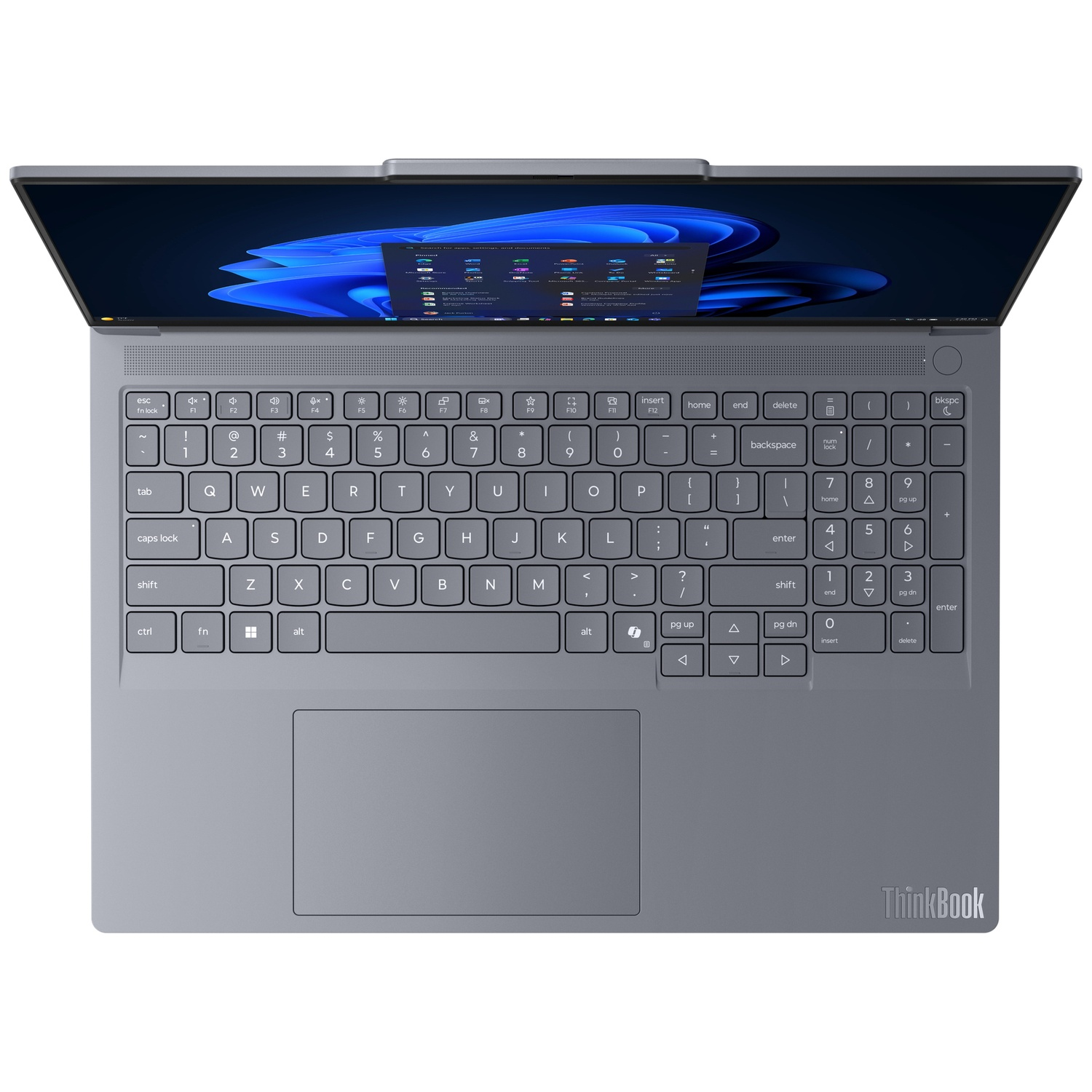 Open gray laptop with keyboard visible. Screen displays a desktop with app icons. The touchpad is below the keyboard.