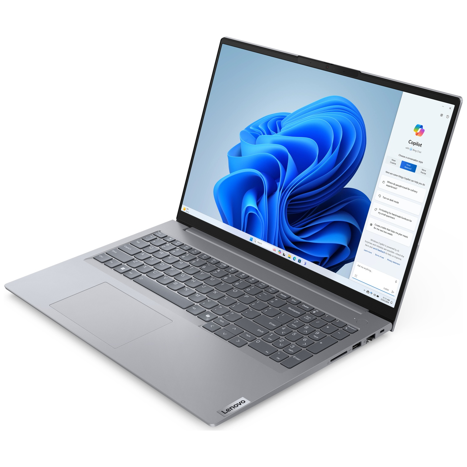 Un ordinateur portable Lenovo est ouvert, affichant une image abstraite bleue sur l'écran. Le clavier est visible, avec un fond blanc.