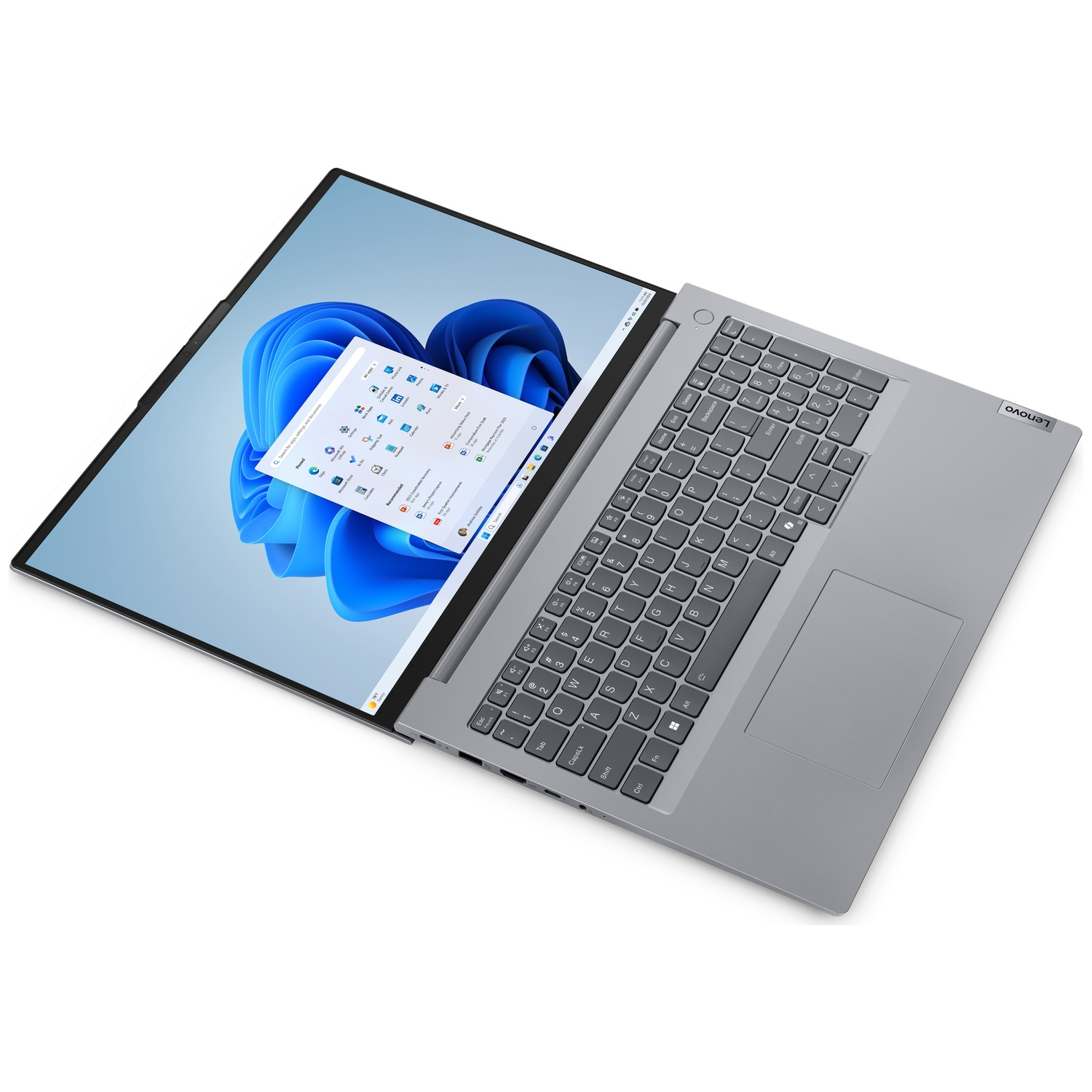 Ordinateur portable Lenovo ouvert. Écran affiche Windows 11 avec icônes et fond bleu tourbillonnant. Clavier visible.