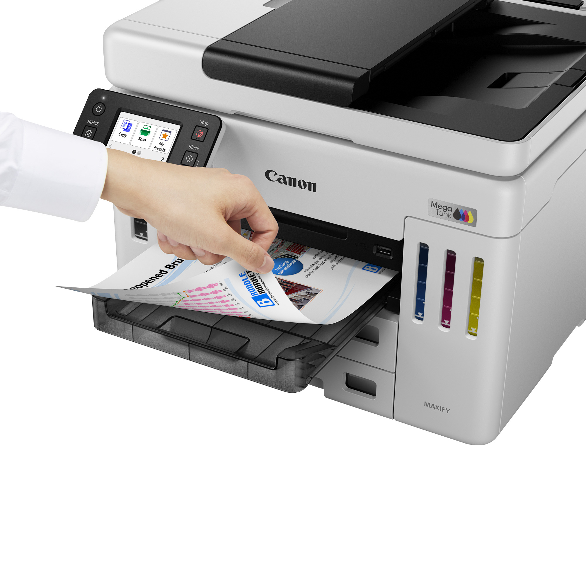 Eine Person legt ein bedrucktes Papier in einen Canon-Drucker ein. Der Drucker ist weiß und grau.