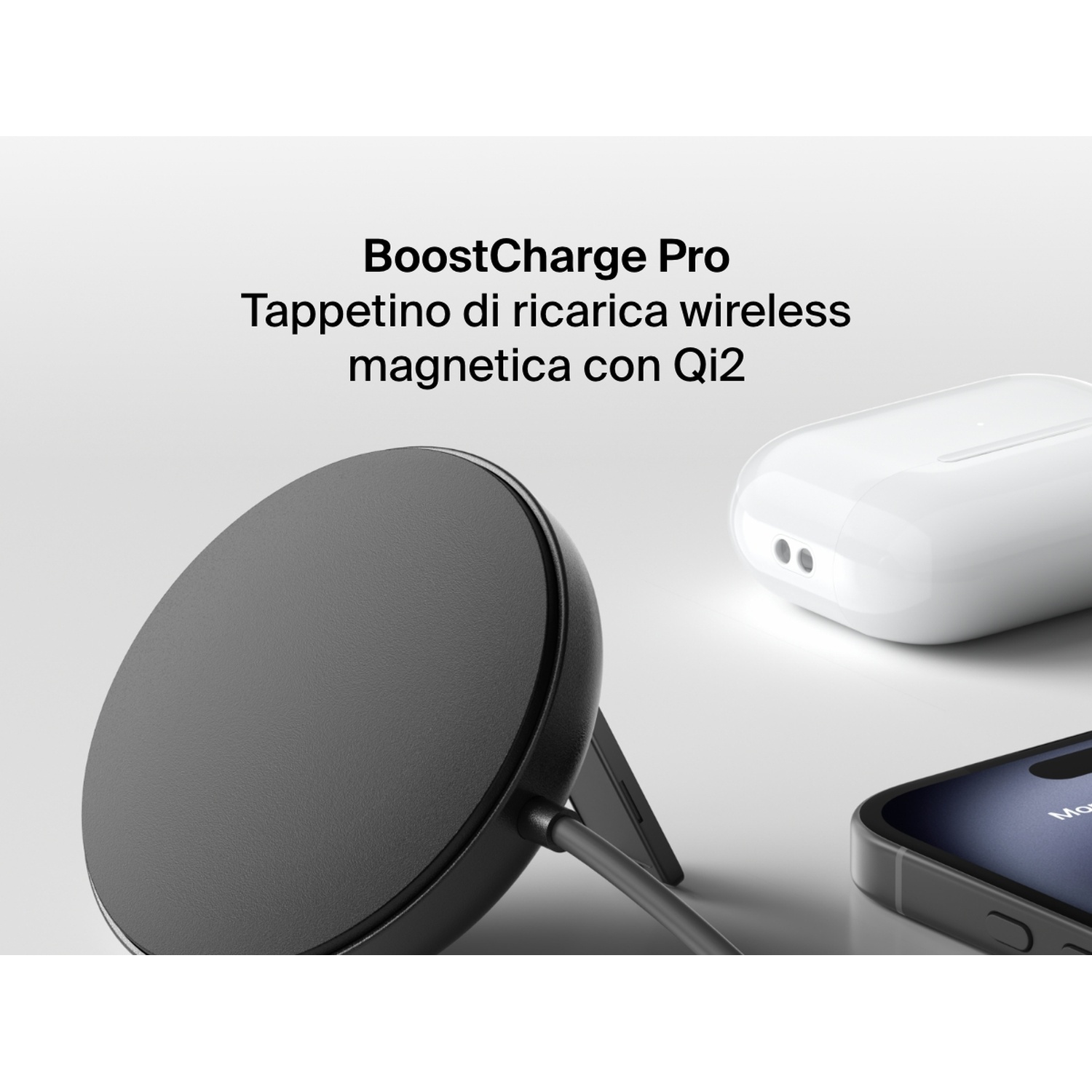 Un caricabatterie wireless nero, una custodia per auricolari wireless bianca e un iPhone nero su una superficie bianca.