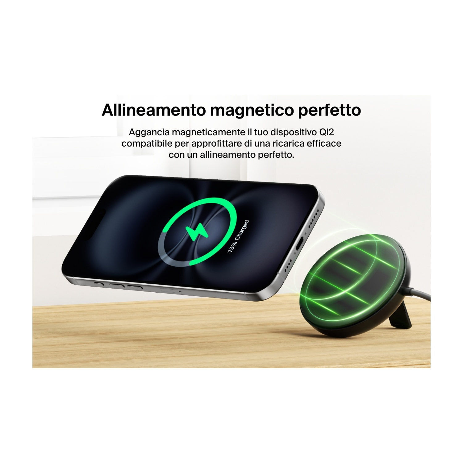 Un telefono si ricarica in modalità wireless sopra una superficie di legno. Un simbolo di ricarica verde è sullo schermo e un pad di ricarica accanto.