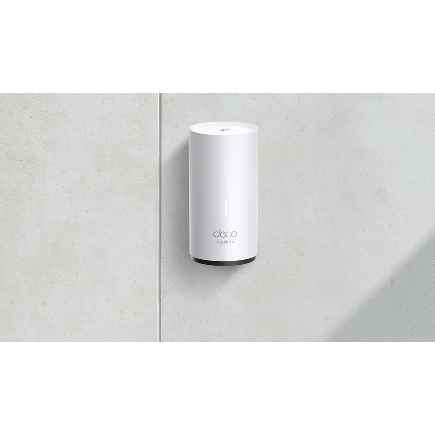 Un appareil extérieur Deco cylindrique blanc est monté sur un mur en béton gris clair. Une ombre est projetée sur le mur.