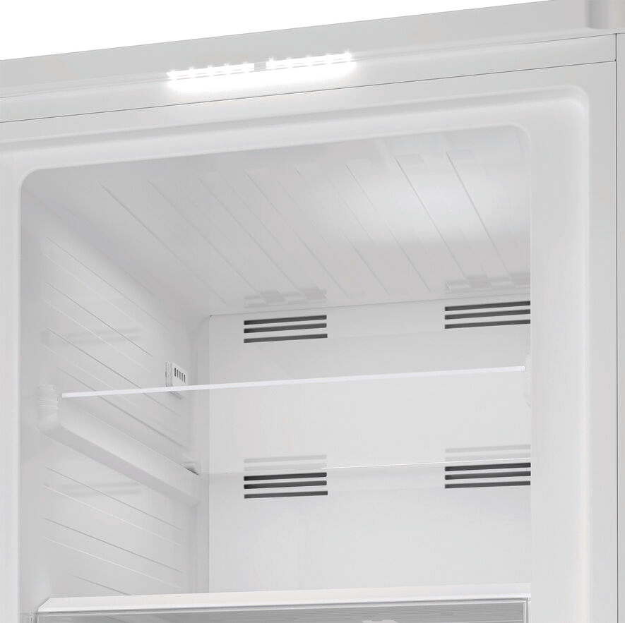 À l'intérieur d'un réfrigérateur blanc, des étagères et des grilles d'aération sont visibles. Une bande lumineuse est en haut. L'image est vivement éclairée.