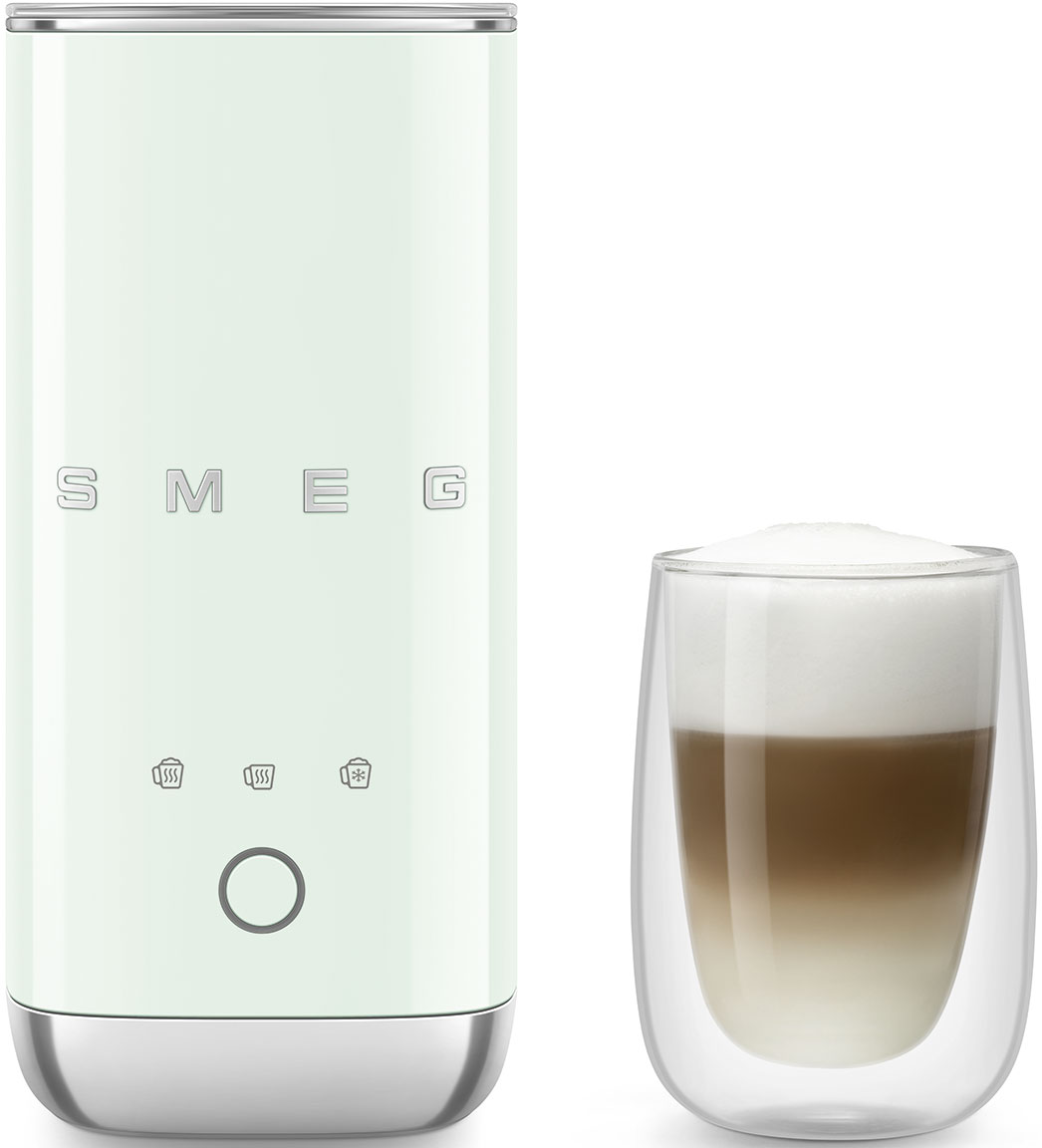 Un montalatte SMEG verde chiaro accanto a un bicchiere di latte macchiato a strati. Il montalatte ha pulsanti e una base argentata. Il bicchiere è trasparente.