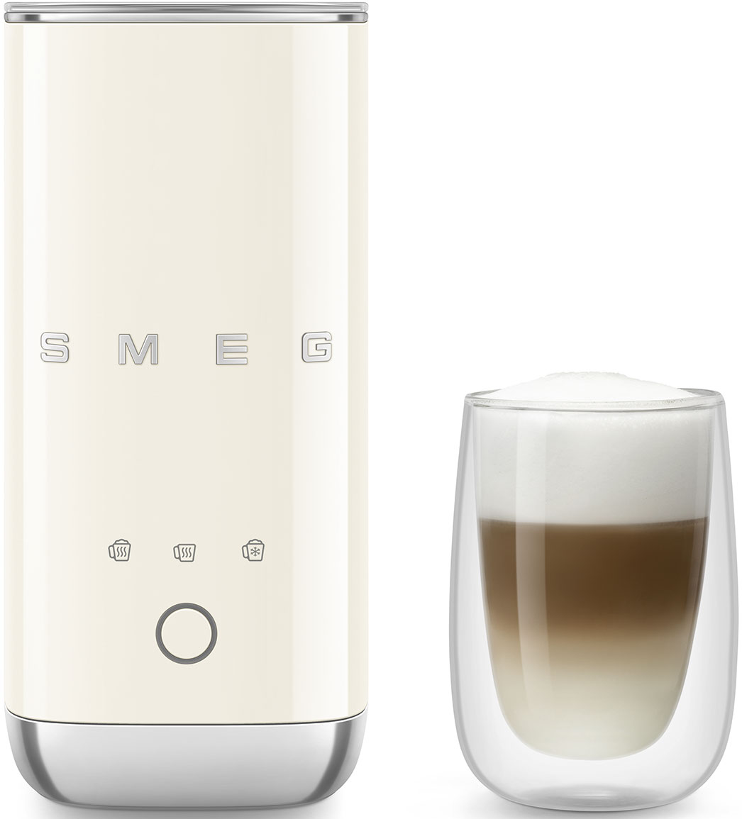 Montalatte SMEG color crema accanto a un bicchiere di latte macchiato a strati. Il montalatte ha pulsanti e una base argentata. Il latte ha schiuma.