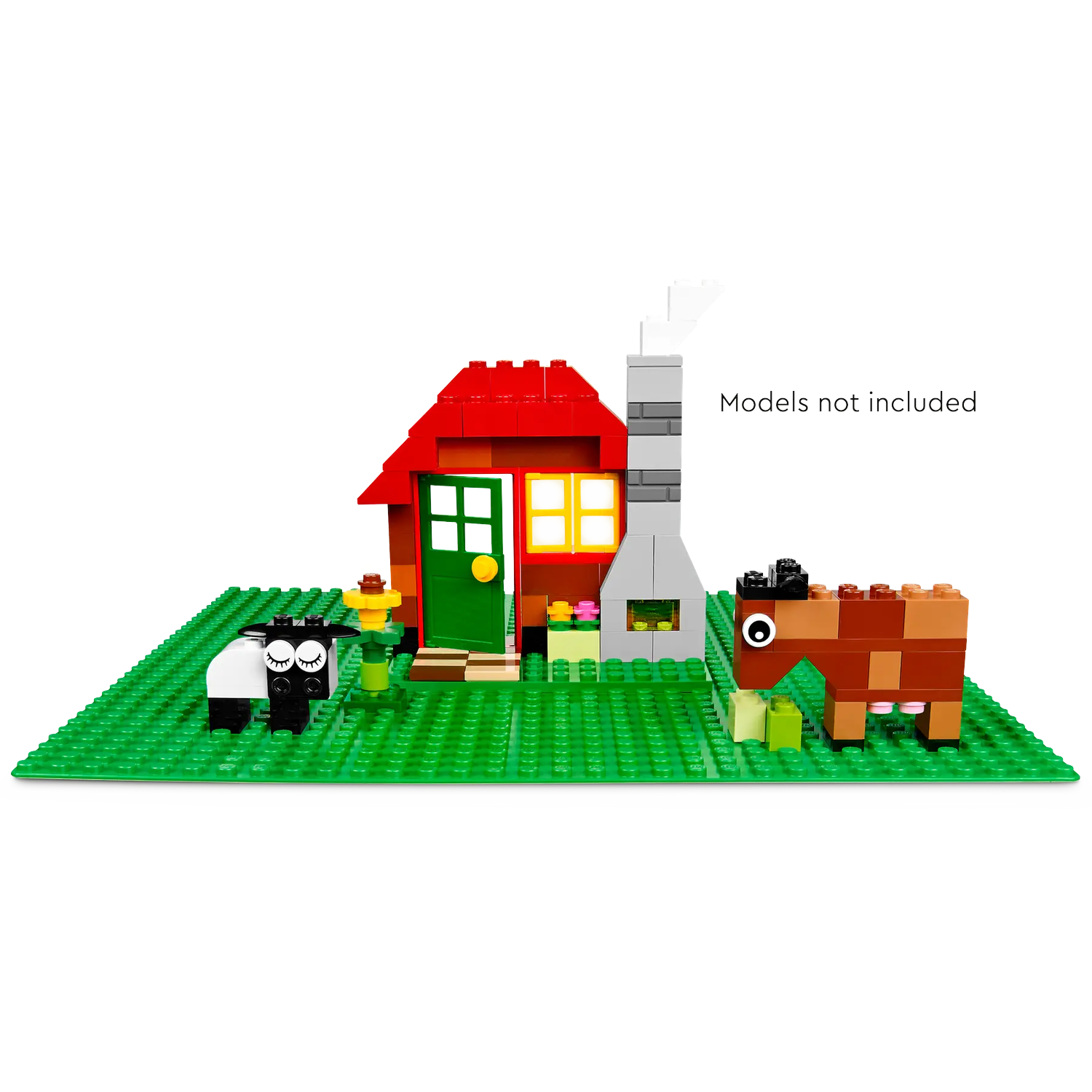 A Lego scene includes a red-roofed house, a chimney, a sheep, and a horse, all on a green baseplate. The scene is set on a white background.