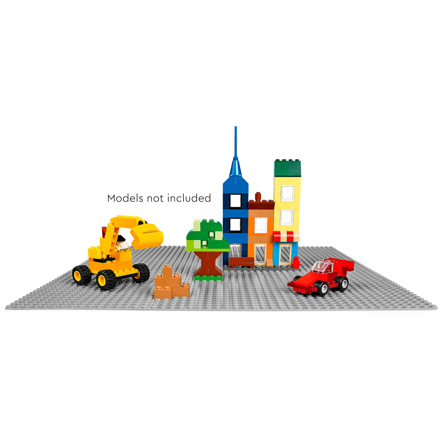 A Lego scene with buildings, excavator, tree, and car on a gray baseplate. The buildings are colorful.