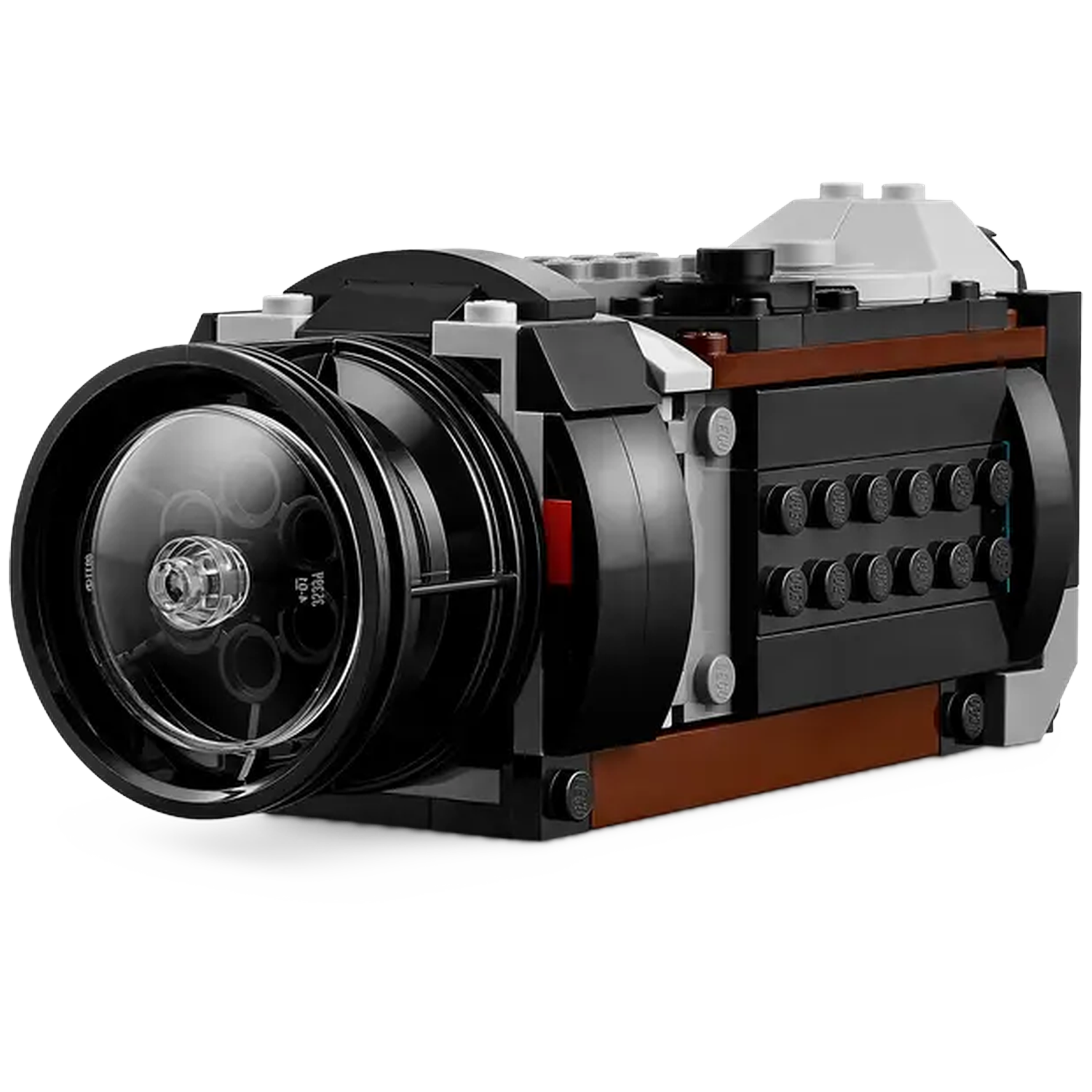 A Lego camera is shown, black with a transparent lens. It has brown and gray details. The camera sits against a white background.