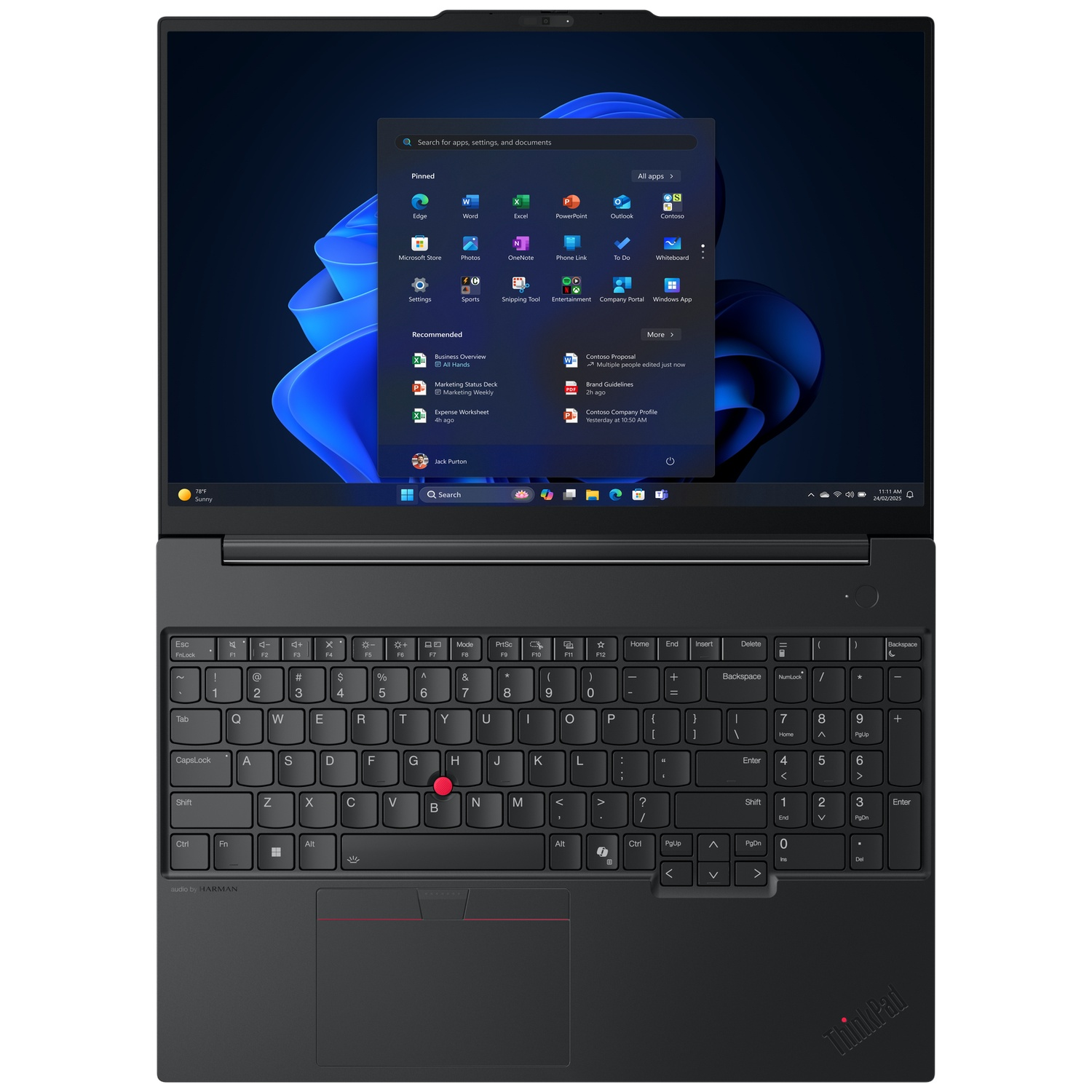 A black laptop displays the Windows 11 interface, showing app icons and a search bar. The keyboard is visible.