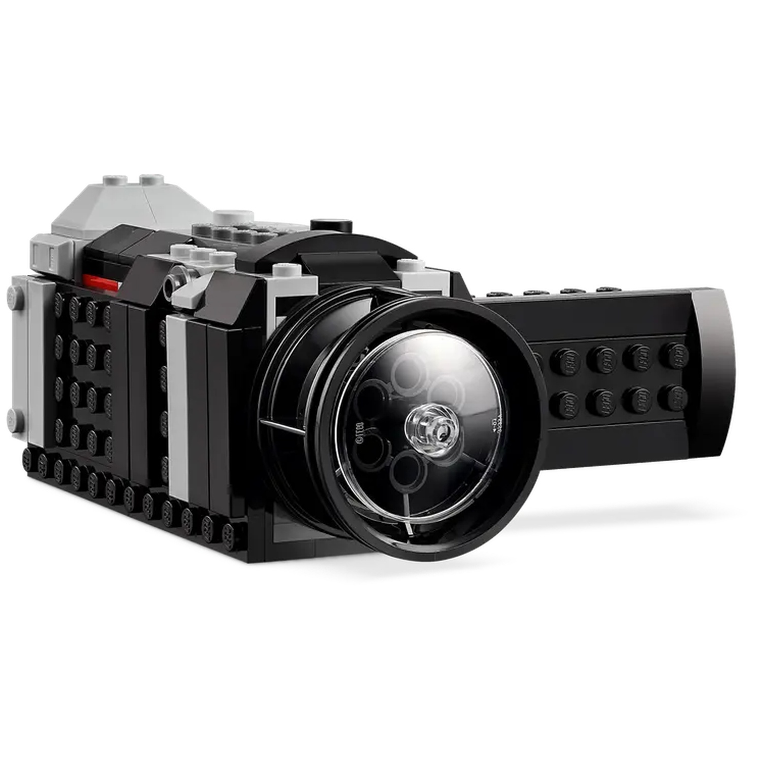 A Lego camera made of black, gray, and red bricks. It has a large lens and a handle on the side. The background is white.