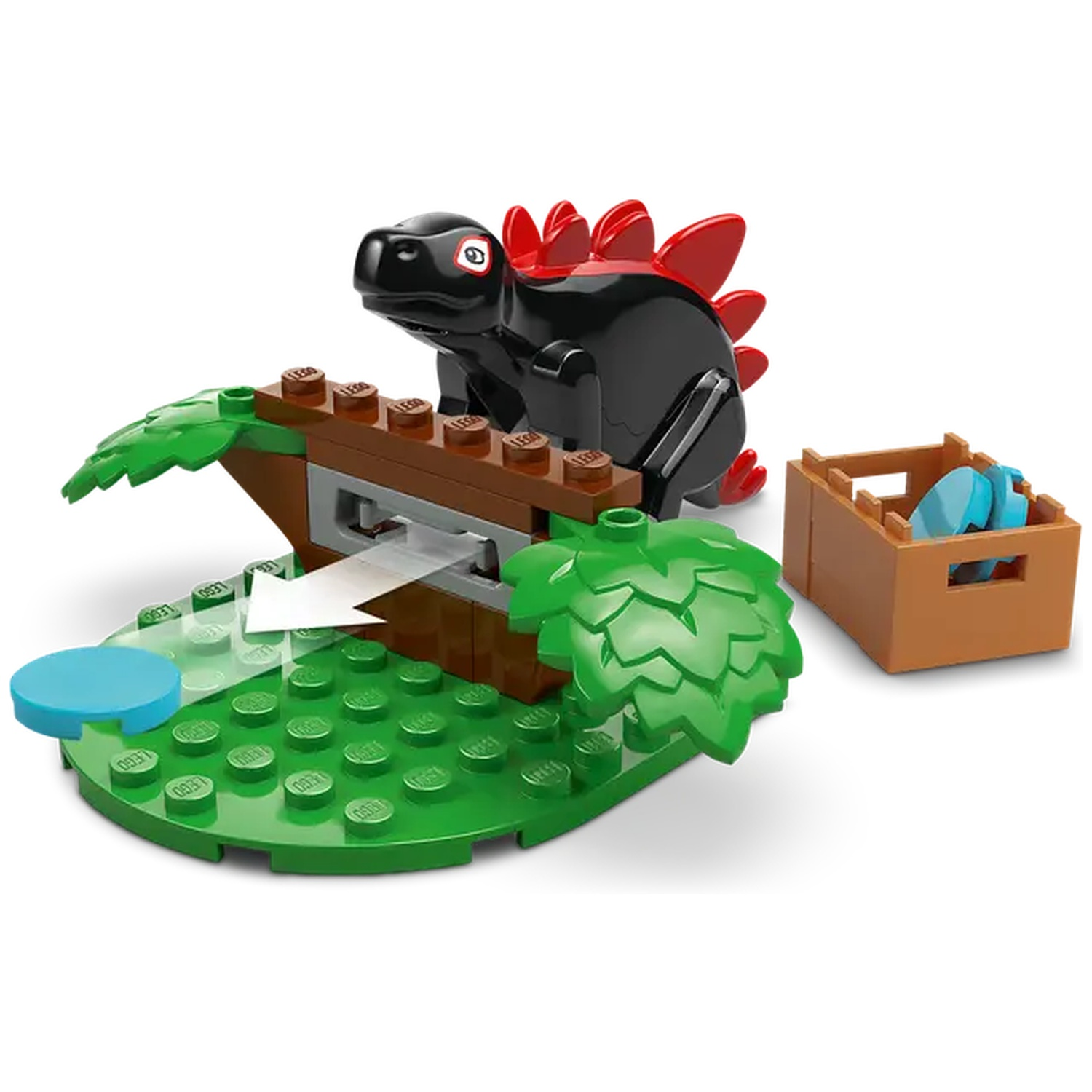 Een zwarte Lego dinosaurus met rode stekels, op een groene basis met een boom, een blauwe schijf en een bruine doos met blauwe items.