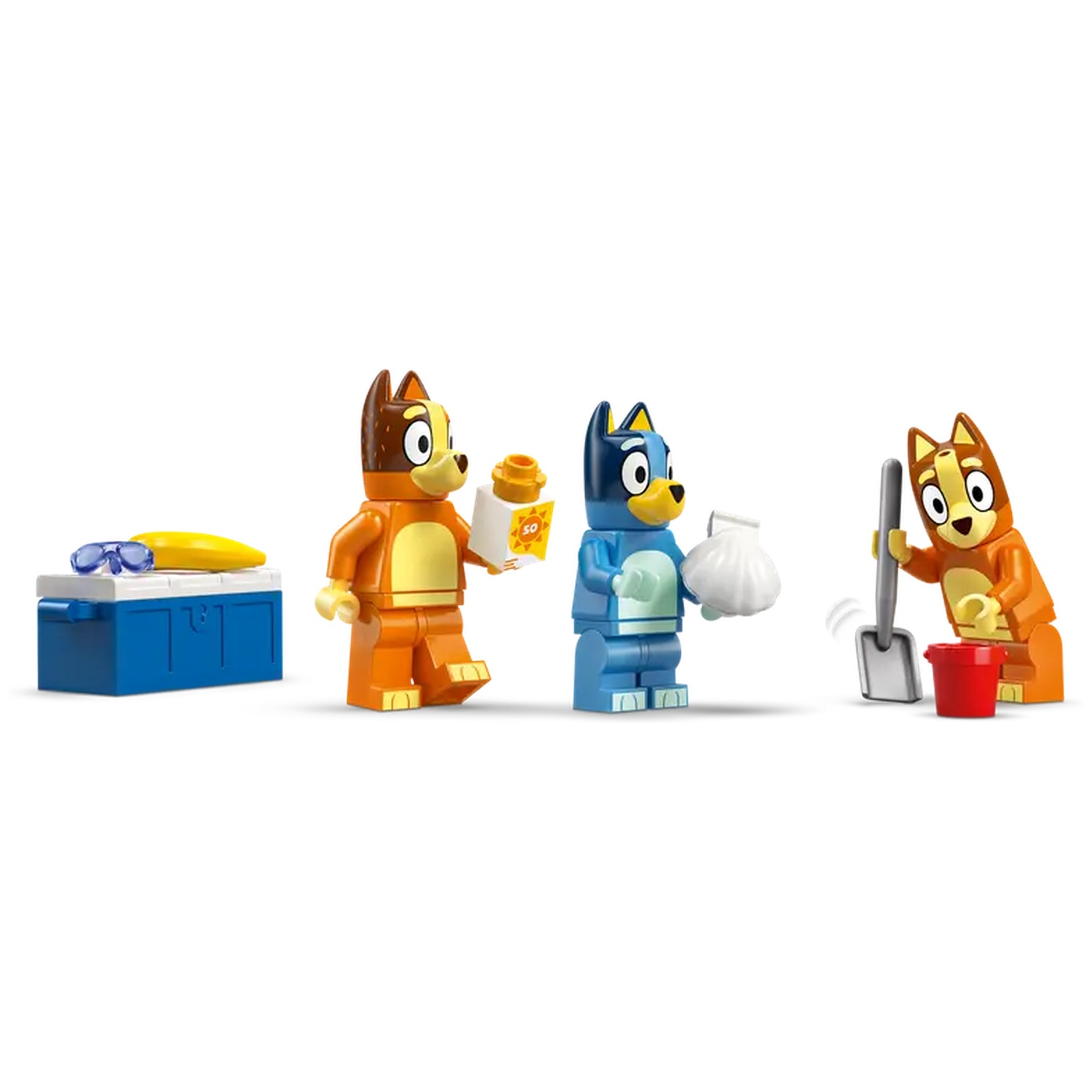 Lego-beeldjes van tekenfilmhonden op het strand. Eén hond houdt zonnebrandcrème vast, een ander een schelp en een ander een schop en een emmer, een koeler.
