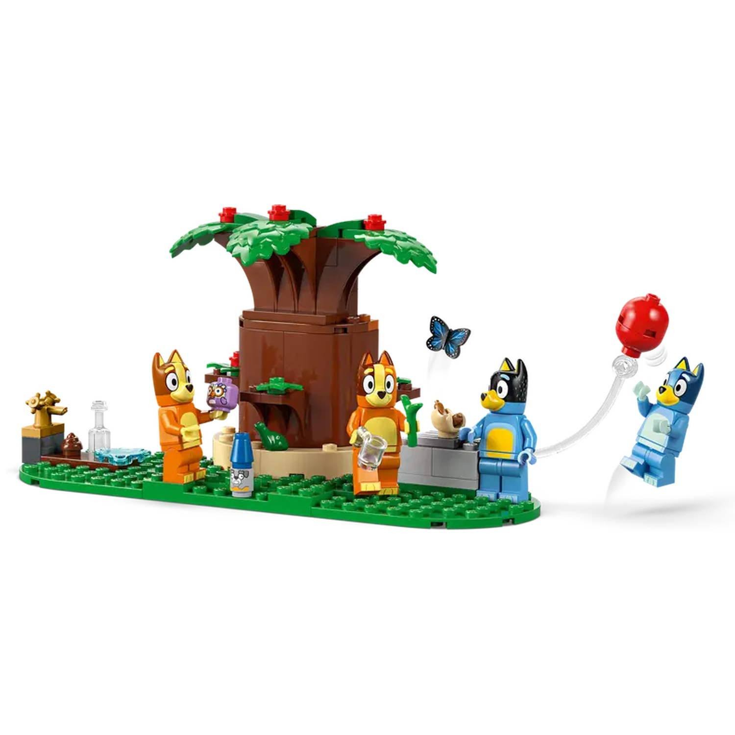 Lego set met cartoonhonden rond een boom. Eén hond houdt een ballon vast, anderen staan bij een boom of eten. Een vlinder vliegt.