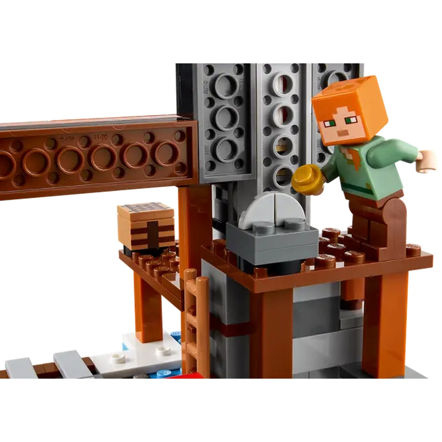 Un ensemble Lego Minecraft avec une figurine tenant un disque d'or. Il comprend des structures en bois et des blocs gris.