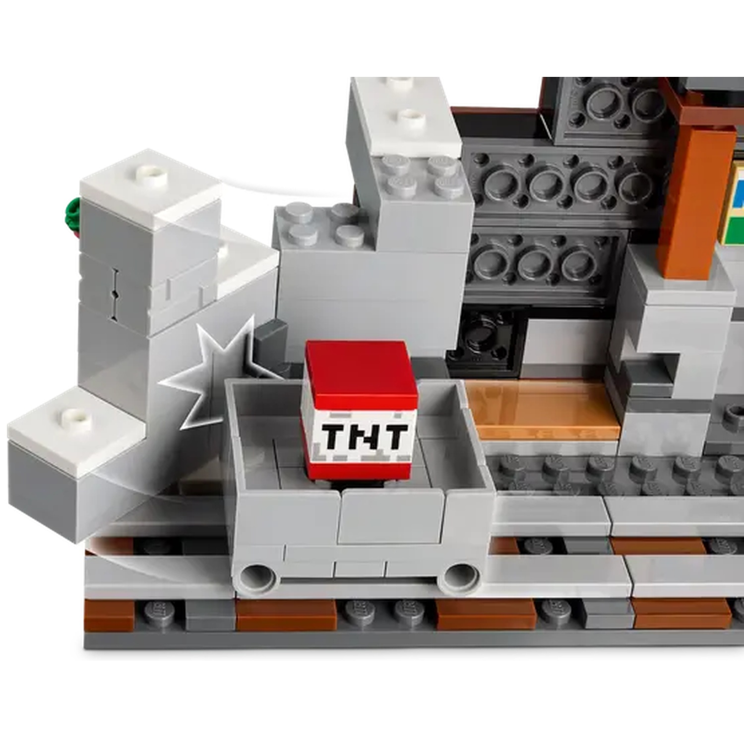 Un ensemble Lego avec un wagon de mine avec du TNT, sur un fond rocheux gris et blanc. Construction détaillée avec des textures variées.