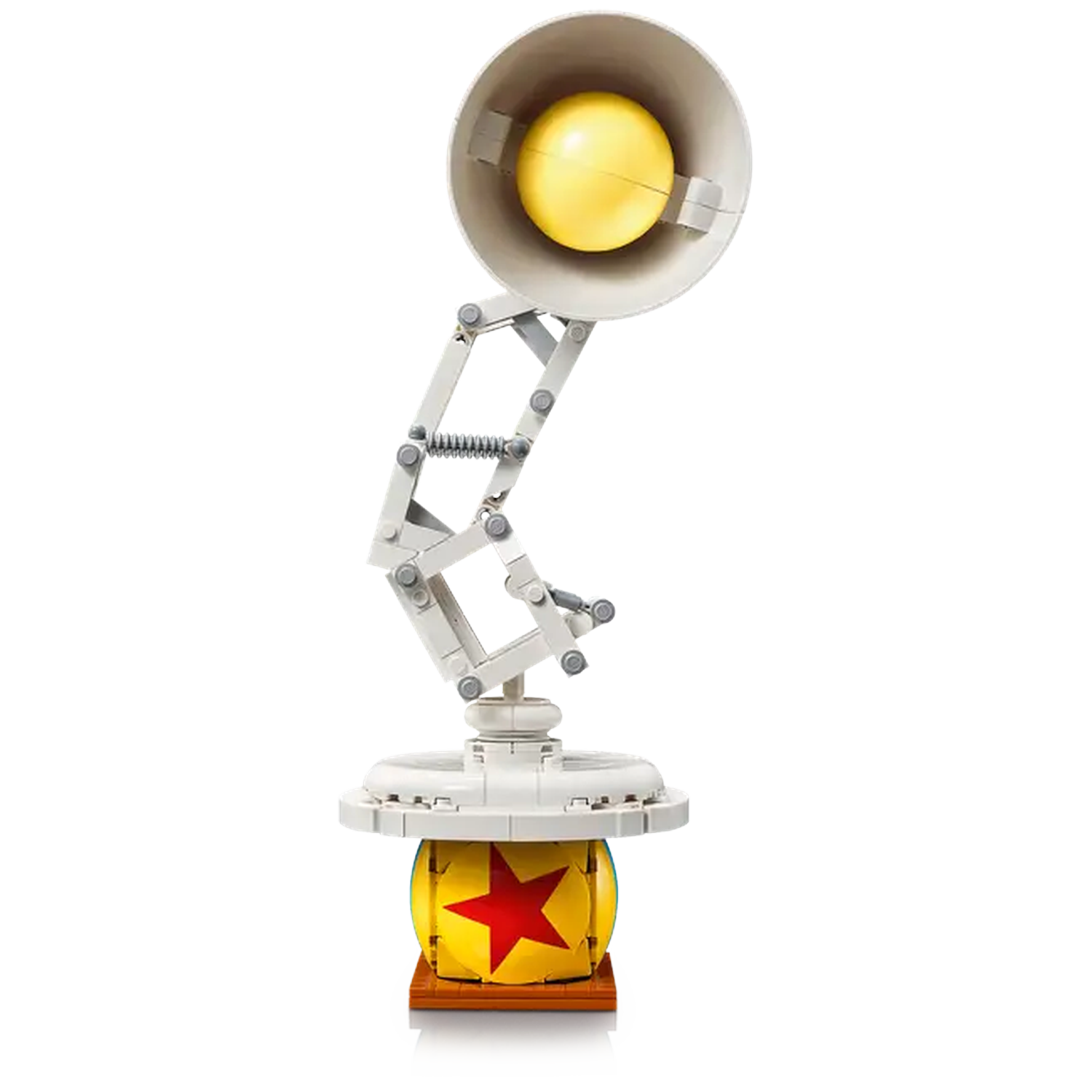 A Lego lamp with a yellow lightbulb, positioned above a yellow ball with a red star on a wooden base.