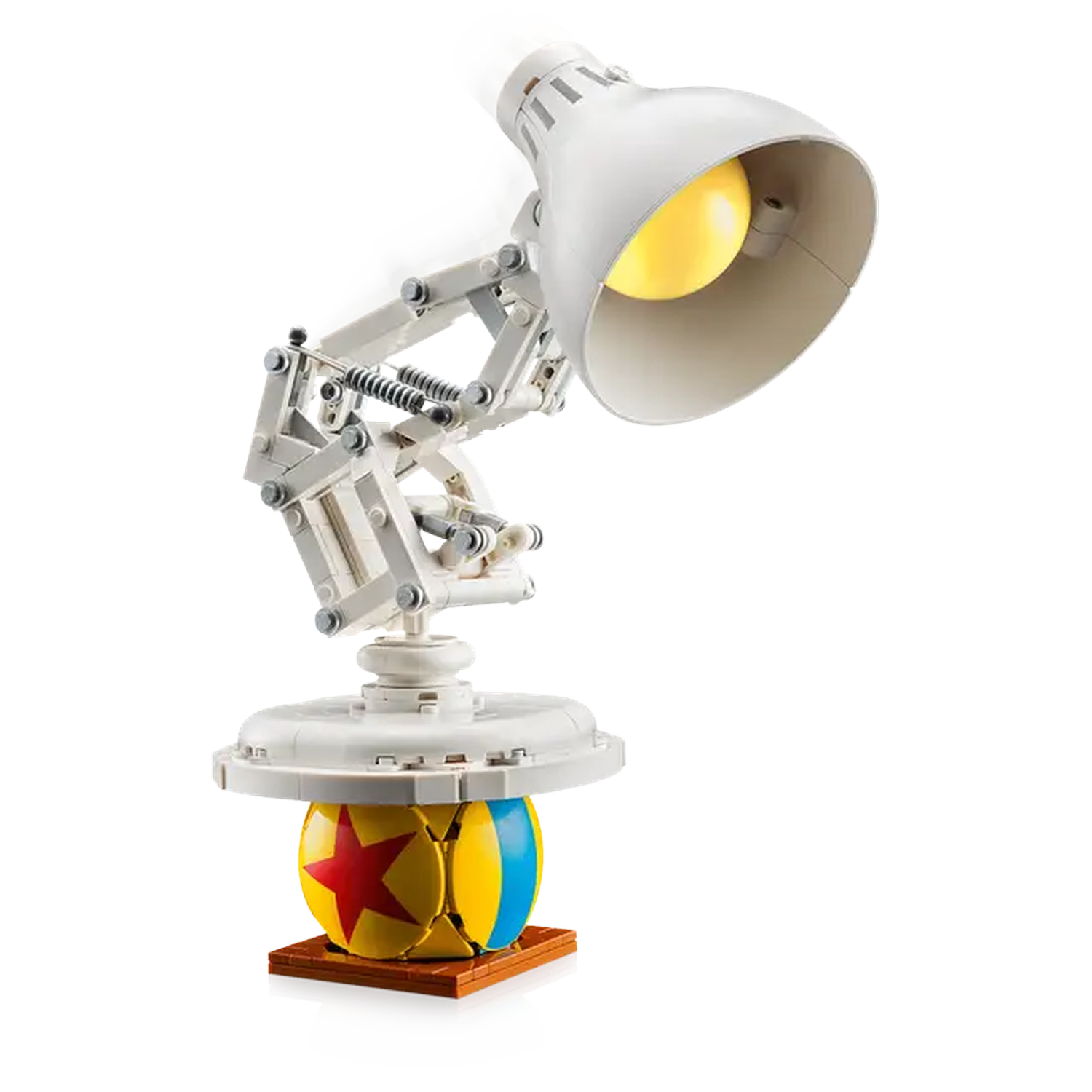 A white desk lamp with a yellow lightbulb, positioned above a ball with a red star and blue stripe.