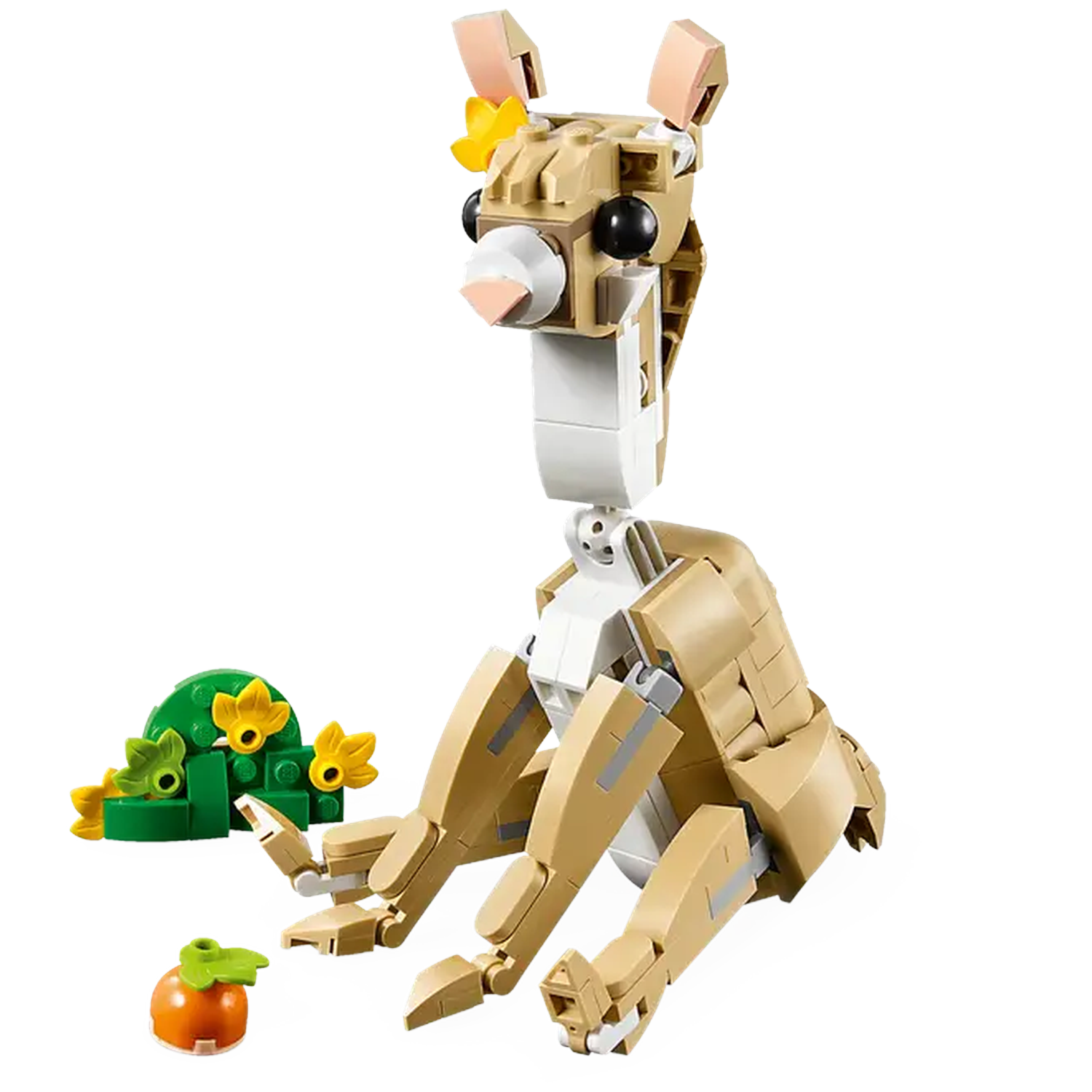 A Lego llama sits, tan with a long neck and flower crown. There's a green bush with yellow flowers and a small orange carrot.