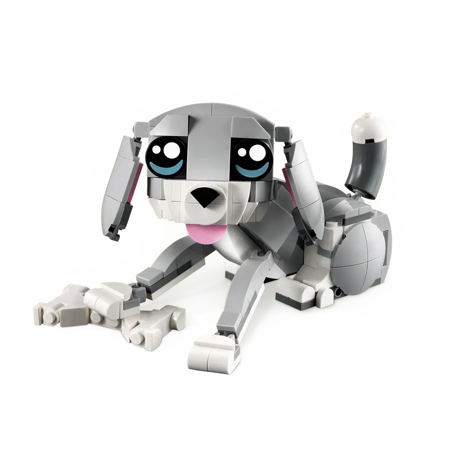 Een grijze en witte Lego-hond met een roze tong, grote ogen en een gekrulde staart, liggend op een wit oppervlak.
