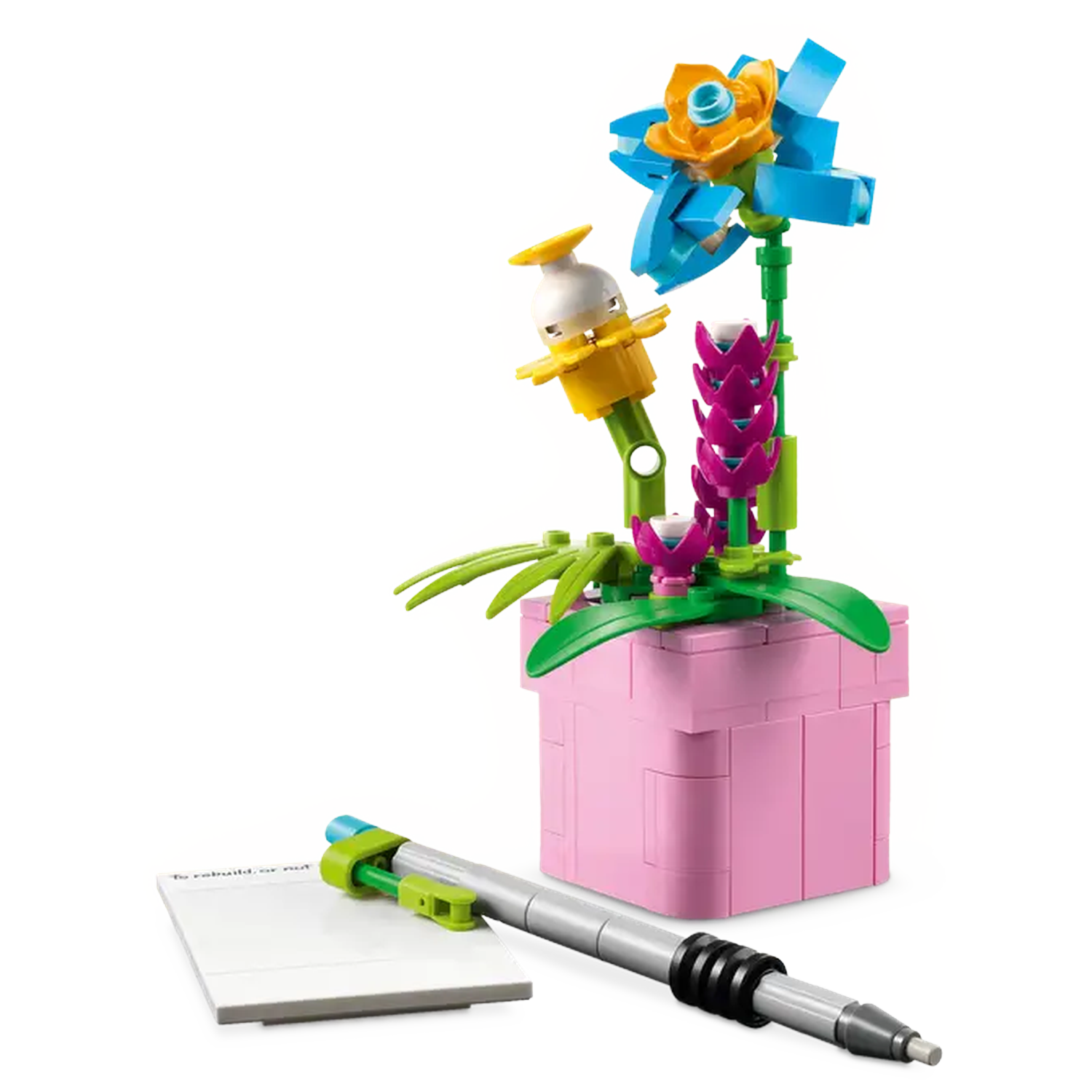 A LEGO flower pot with flowers, a notepad, and a pen. The flowers are blue, pink, and yellow. The pot is pink.