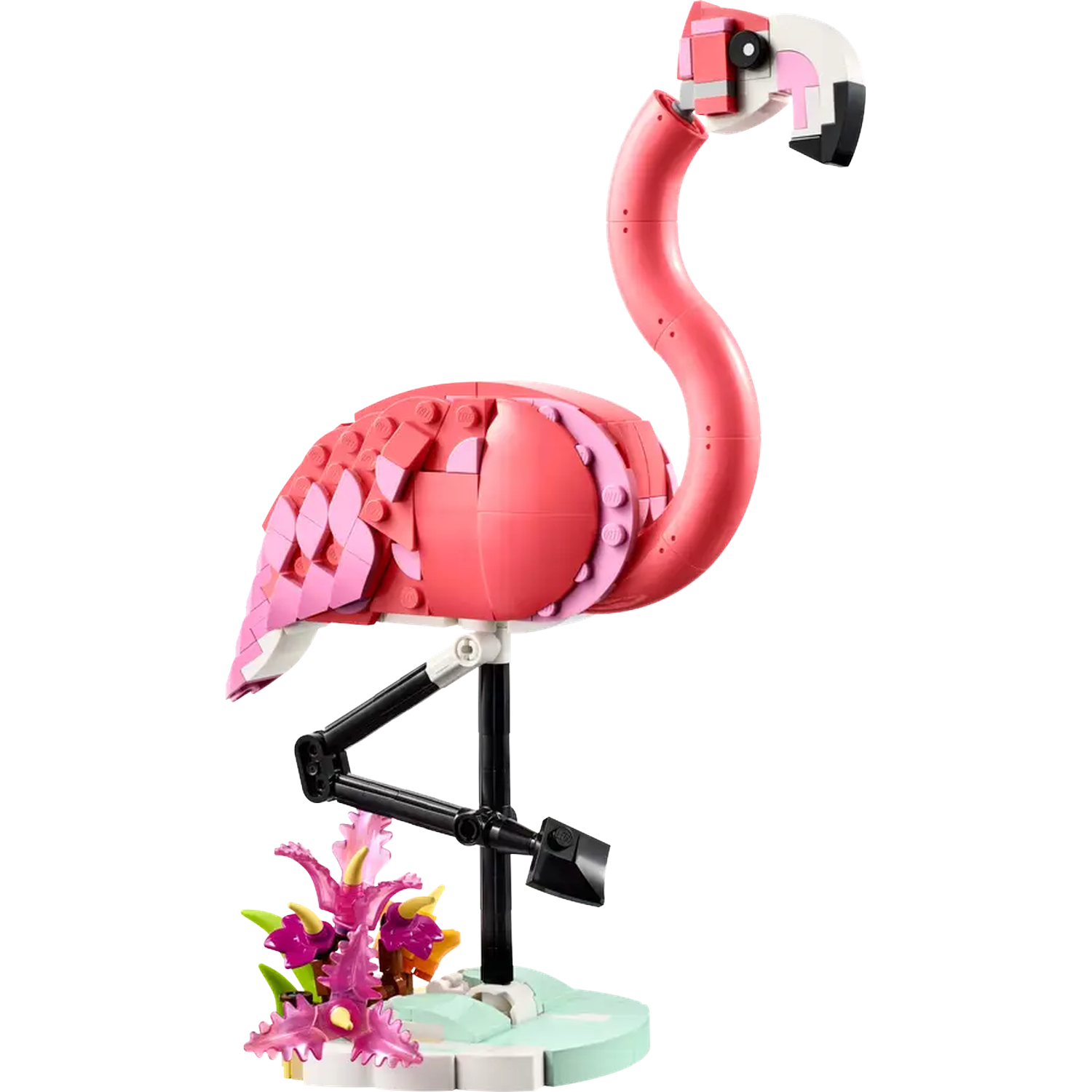 A Lego flamingo, primarily pink with black legs, stands on a light green base with purple flowers. The head is white and black.