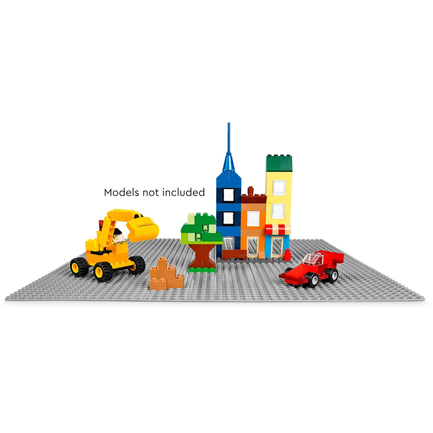 Een scène met speelgoedgebouwen, een gele graafmachine, een rode raceauto, een boom en blokken op een grijze basis.