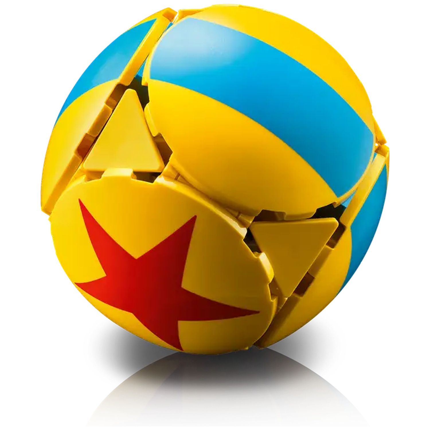 A yellow ball with blue stripes and a red star. It has a triangular design and is sitting on a reflective surface.