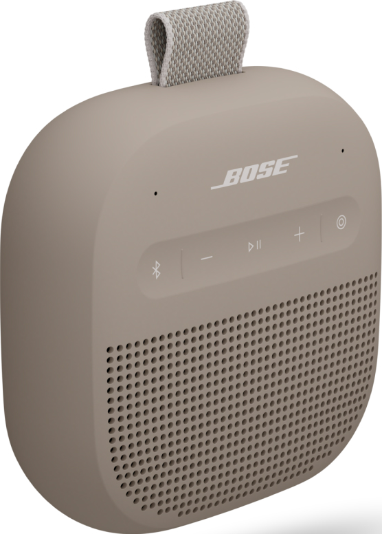 Beige tragbarer Bose-Lautsprecher mit Mesh-Lautsprechergrill, Bedientasten und Stoffgriff. Das Bose-Logo ist sichtbar.