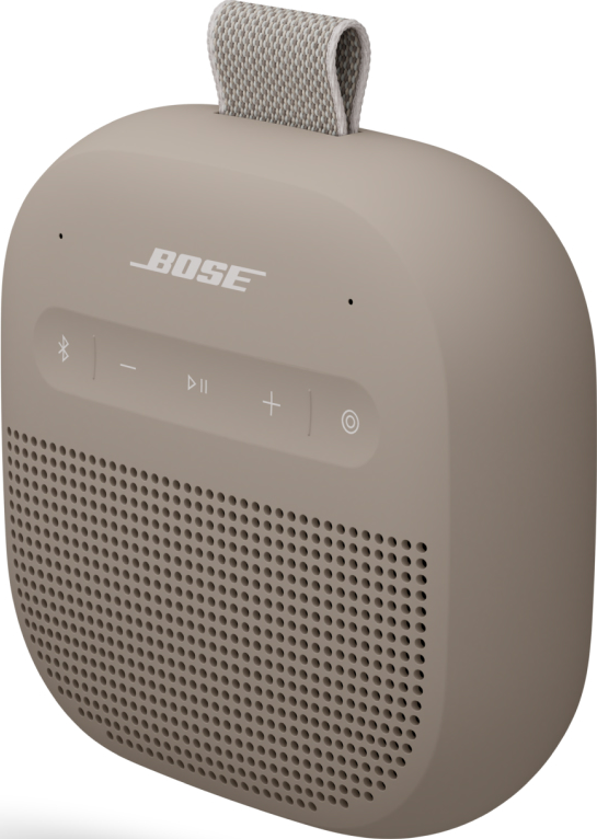 Ein beigefarbener tragbarer Bose-Lautsprecher mit Stoffgriff. Er hat Bedienelemente und ein perforiertes Lautsprechergitter.