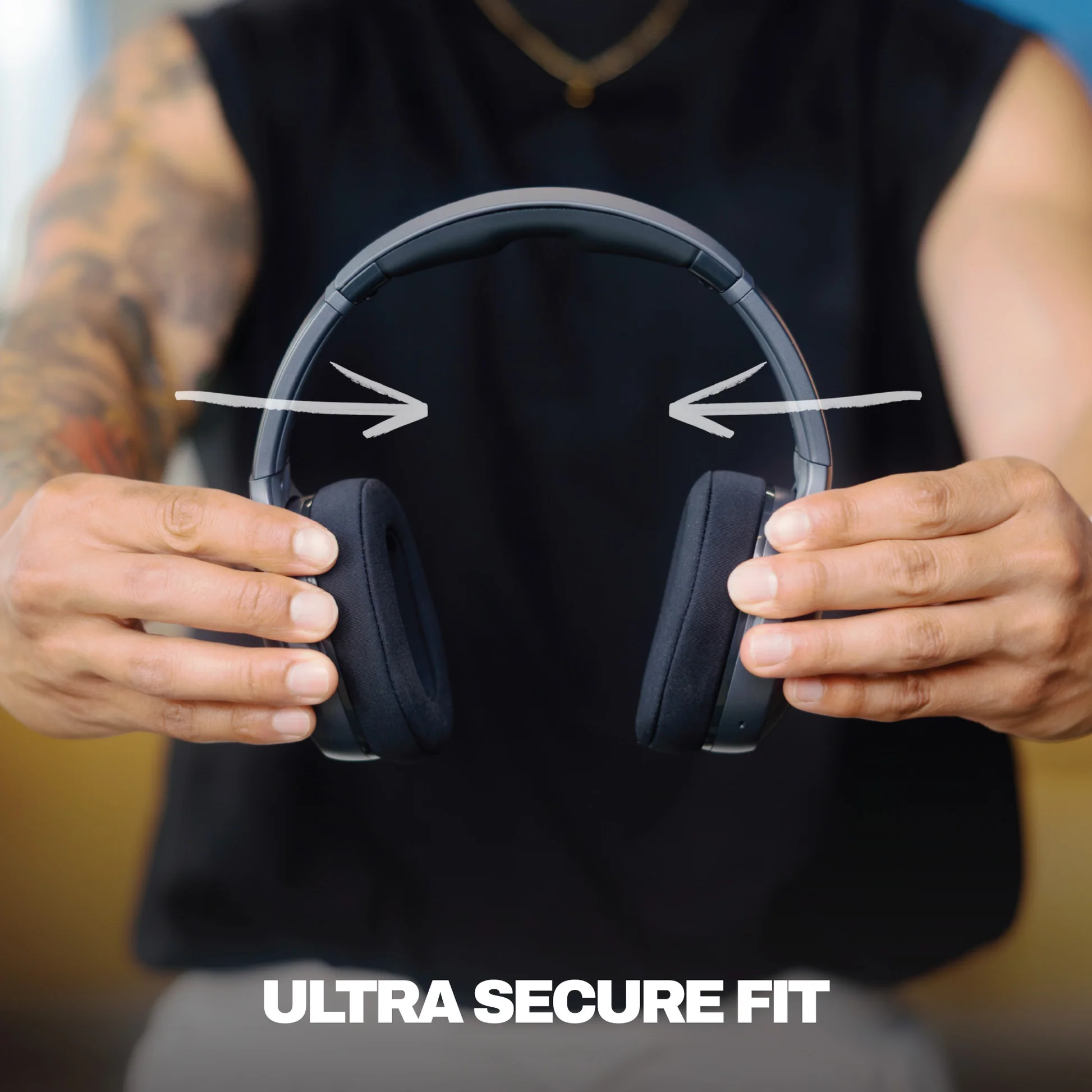 Una persona tiene delle cuffie nere. Le frecce puntano ai padiglioni. Il testo dice 'ULTRA SECURE FIT'.