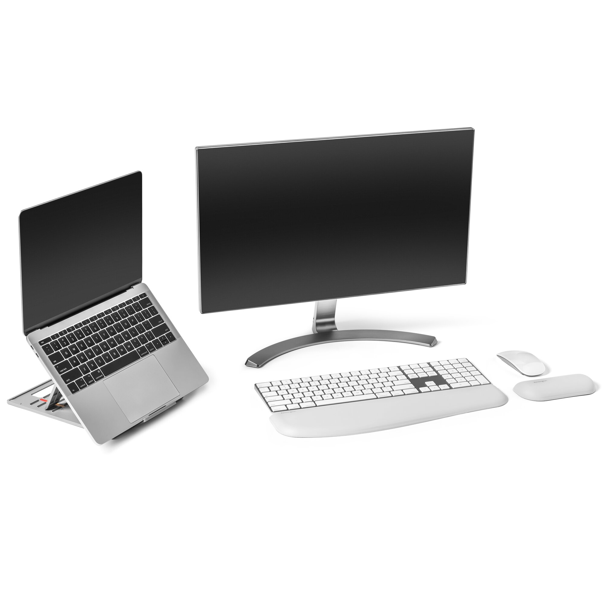 Ein Laptop auf einem Ständer, ein Monitor, eine Tastatur mit Handgelenkauflage, eine Maus und ein Mauspad auf weißer Oberfläche.