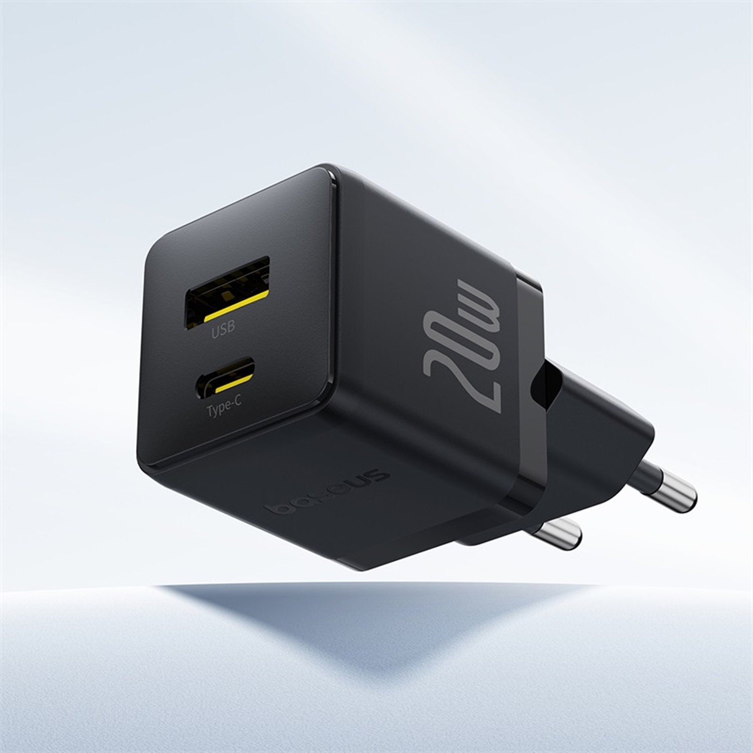 Un cargador USB negro de 20W. Tiene un puerto USB y uno Tipo-C. La marca es visible. Tiene dos clavijas para enchufar.