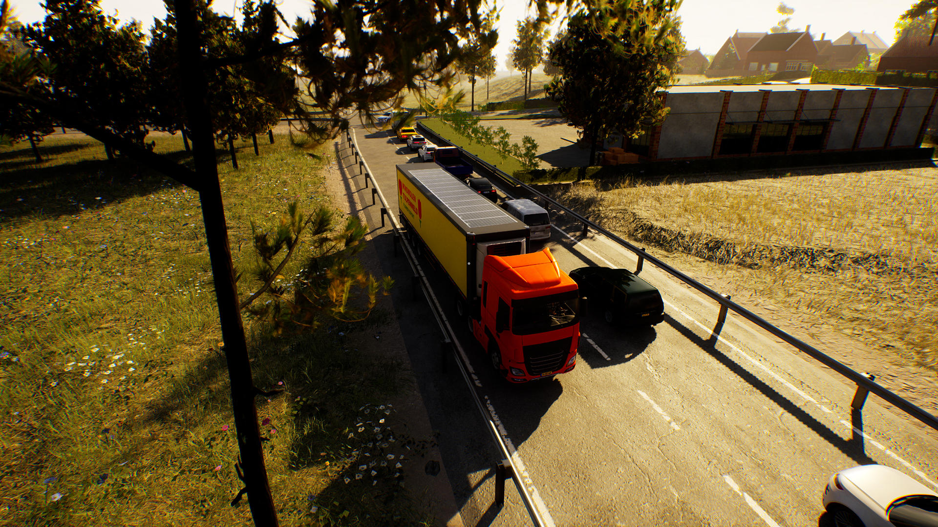 Ein roter DHL-LKW auf der Straße mit anderen Autos. Grünes Gras und Bäume an den Seiten. Häuser sind im Hintergrund.