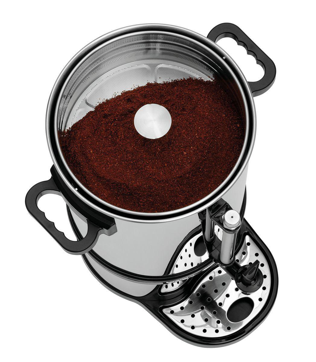 Eine Kaffeemaschine aus Edelstahl mit Kaffeepulver im Inneren. Sie hat schwarze Griffe und einen schwarzen Sockel mit Löchern.