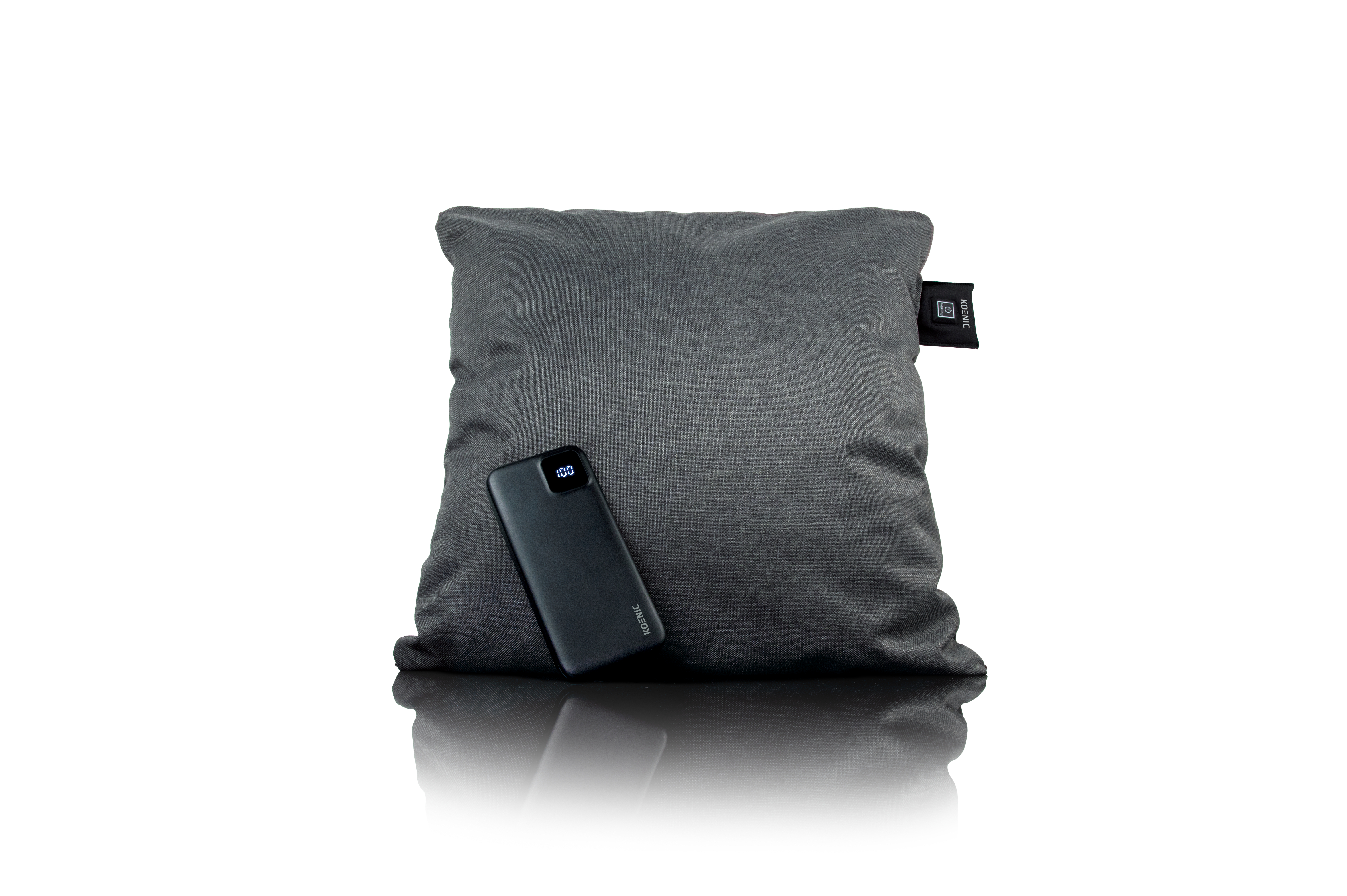 Ein graues Kissen mit einer schwarzen Powerbank, die 100 % Ladung anzeigt. Das Kissen hat ein Koenic-Etikett.