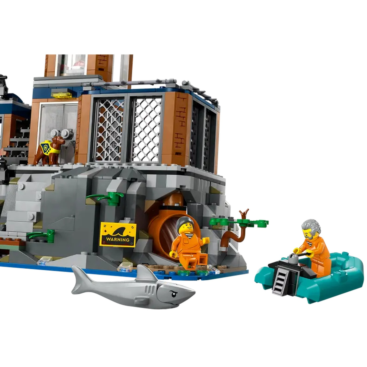 Ensemble Lego : bâtiment avec figurines, requin et bateau. Un personnage sort d'un tunnel. Un autre dirige le bateau. Un chien est sur le bâtiment.