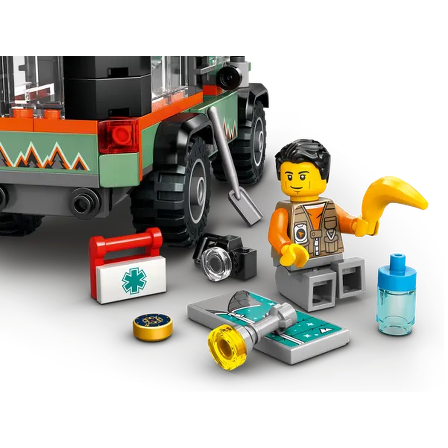 Lego set with a green and orange vehicle, a minifigure, medical kit, camera, and other accessories on a white surface.