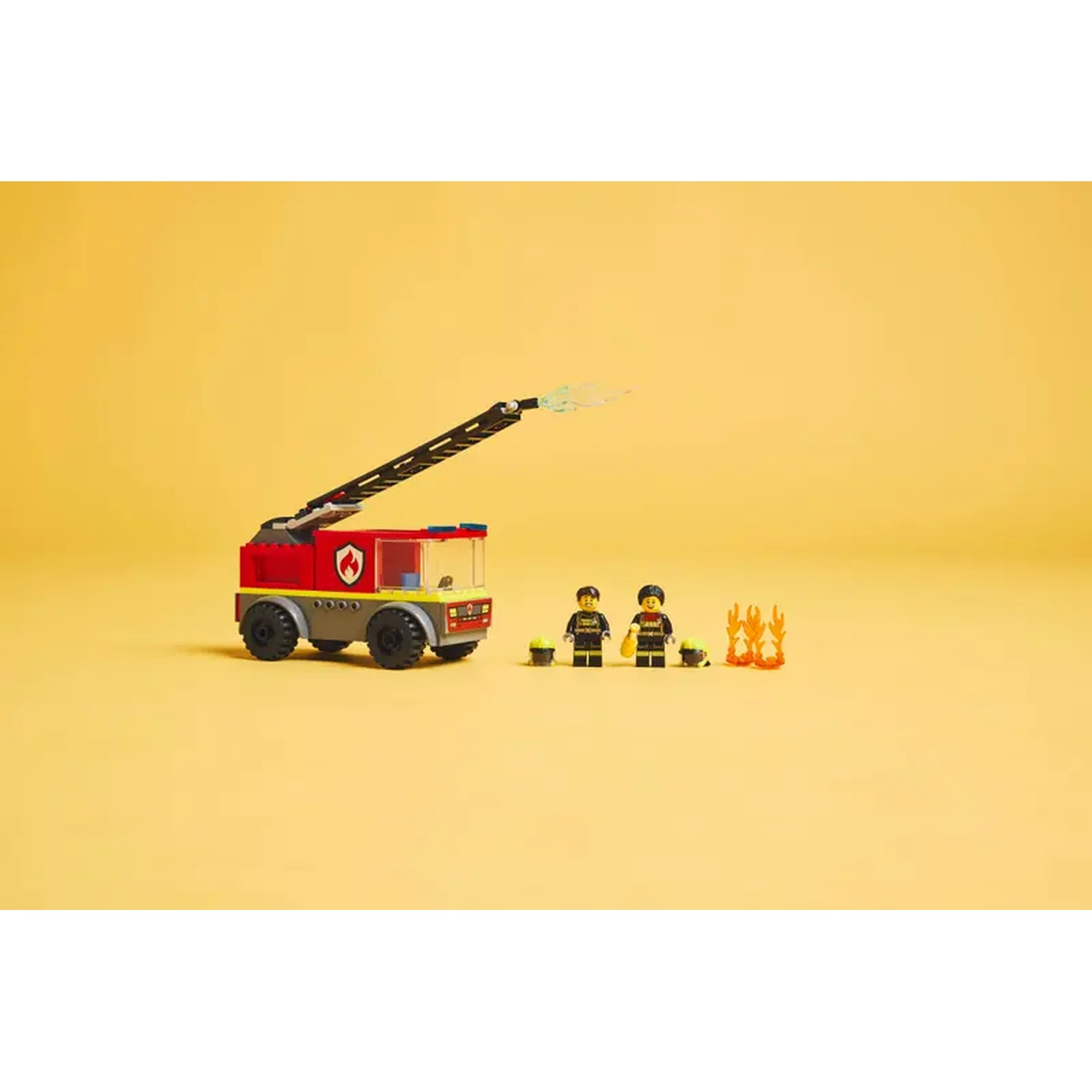 A Lego fire truck with an extended ladder, two Lego firefighters, a small fire, and a yellow background.