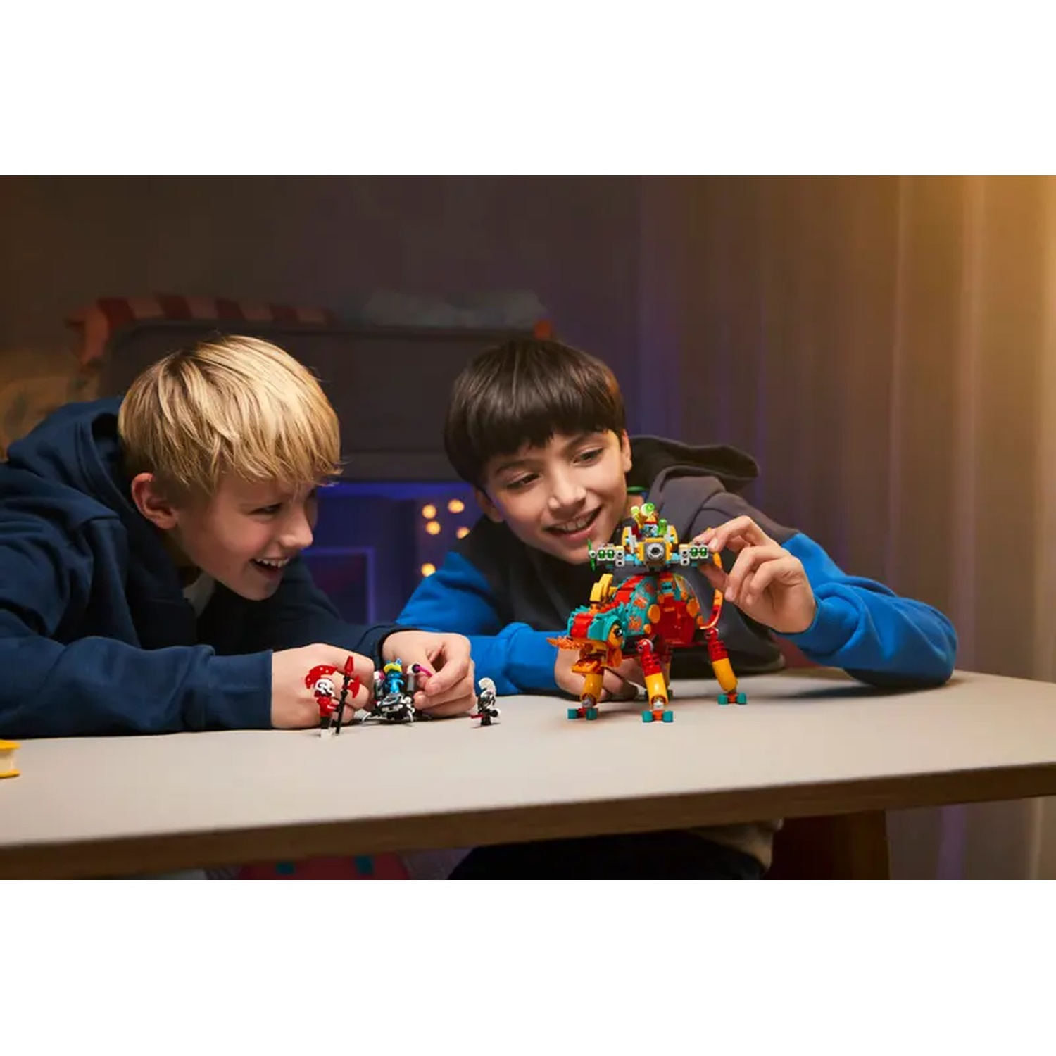 Twee jongens bouwen met Lego. Eén houdt een rood en geel Lego-dier vast. De ander heeft Lego-figuren.
