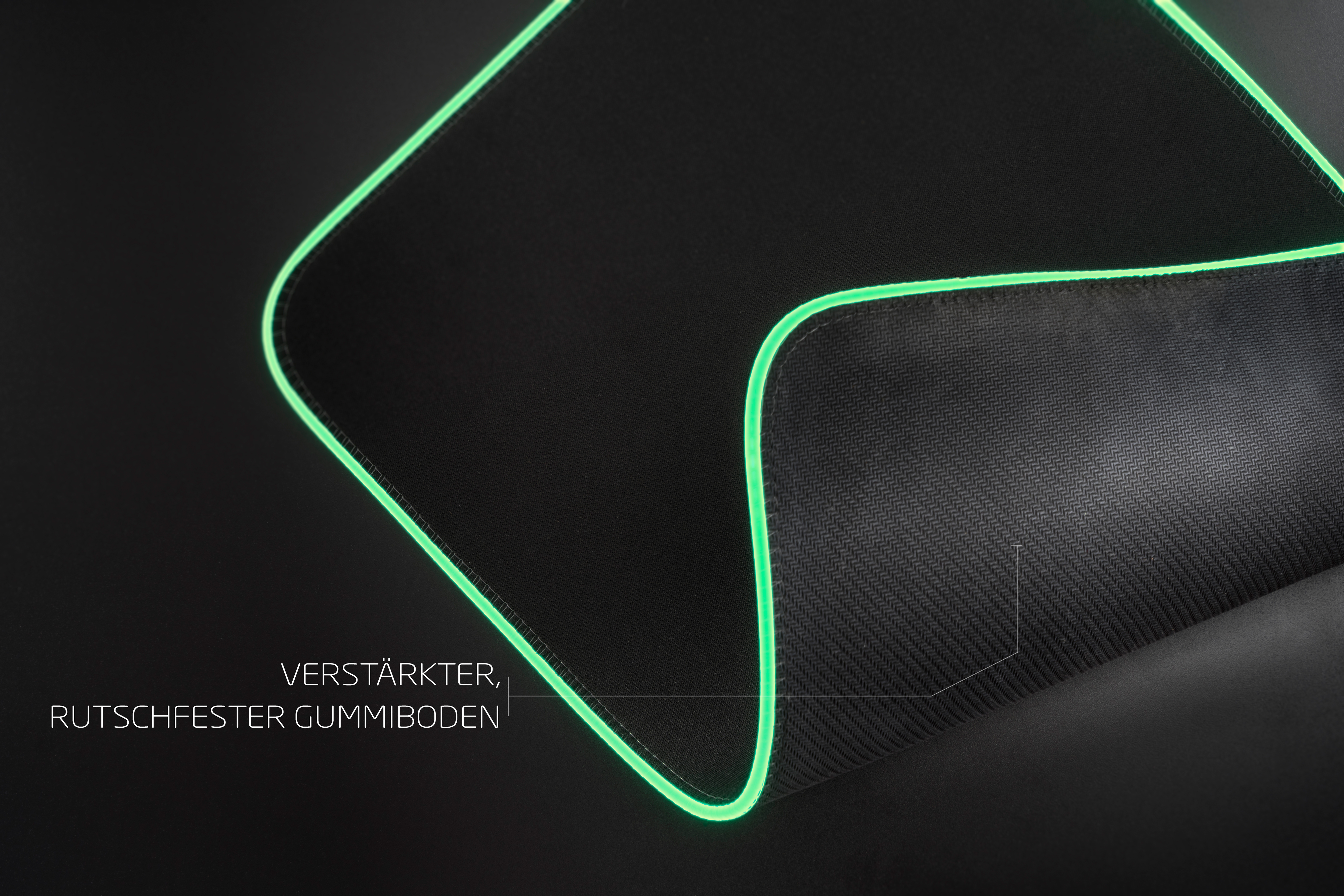 Czarna podkładka pod mysz z zielonymi świecącymi krawędziami. Tekstura. Tekst: wzmocniona, antypoślizgowa gumowa podstawa.